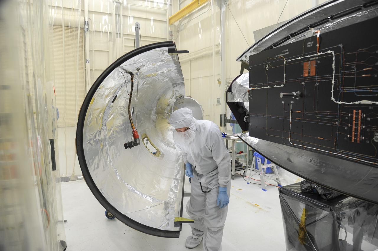 VANDENBERG AFB – Orbital Sciences team members move the second half of the payload fairing before it is placed over NASA's IRIS spacecraft. The fairing connects to the nose of the Orbital Sciences Pegasus XL rocket that will lift the solar observatory into orbit in June. The work is taking place in a hangar at Vandenberg Air Force Base where IRIS, short for Interface Region Imaging Spectrograph, is being prepared for launch on a Pegasus XL rocket. Scheduled for launch from Vandenberg June 26, IRIS will open a new window of discovery by tracing the flow of energy and plasma through the chromospheres and transition region into the sun’s corona using spectrometry and imaging. IRIS fills a crucial gap in our ability to advance studies of the sun-to-Earth connection by tracing the flow of energy and plasma through the foundation of the corona and the region around the sun known as the heliosphere. Photo credit: NASA/Tony Vauclin