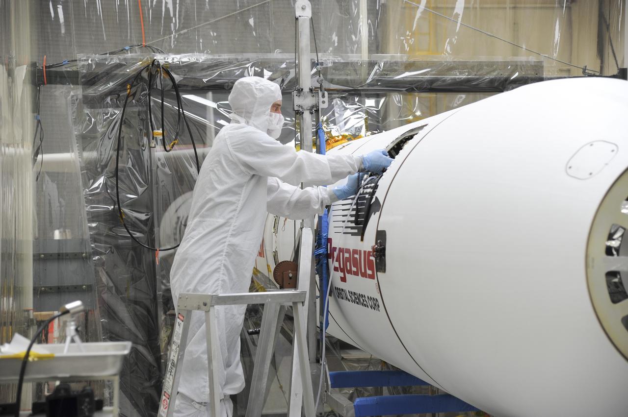 VANDENBERG AFB – Orbital Sciences engineers connect the payload fairing over NASA's IRIS spacecraft. The fairing connects to the nose of the Orbital Sciences Pegasus XL rocket that will lift the solar observatory into orbit in June. The work is taking place in a hangar at Vandenberg Air Force Base where IRIS, short for Interface Region Imaging Spectrograph, is being prepared for launch on a Pegasus XL rocket. Scheduled for launch from Vandenberg June 26, IRIS will open a new window of discovery by tracing the flow of energy and plasma through the chromospheres and transition region into the sun’s corona using spectrometry and imaging. IRIS fills a crucial gap in our ability to advance studies of the sun-to-Earth connection by tracing the flow of energy and plasma through the foundation of the corona and the region around the sun known as the heliosphere. Photo credit: NASA/Tony Vauclin