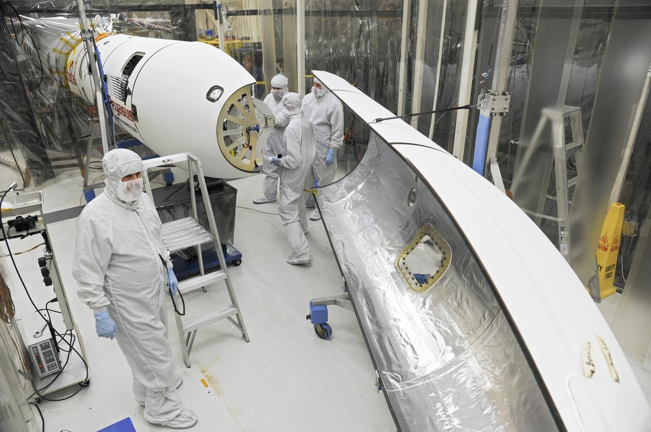 VANDENBERG AFB – Orbital Sciences team members move the second half of the payload fairing before it is placed over NASA's IRIS spacecraft. The fairing connects to the nose of the Orbital Sciences Pegasus XL rocket that will lift the solar observatory into orbit in June. The work is taking place in a hangar at Vandenberg Air Force Base where IRIS, short for Interface Region Imaging Spectrograph, is being prepared for launch on a Pegasus XL rocket. Scheduled for launch from Vandenberg June 26, IRIS will open a new window of discovery by tracing the flow of energy and plasma through the chromospheres and transition region into the sun’s corona using spectrometry and imaging. IRIS fills a crucial gap in our ability to advance studies of the sun-to-Earth connection by tracing the flow of energy and plasma through the foundation of the corona and the region around the sun known as the heliosphere. Photo credit: NASA/Tony Vauclin