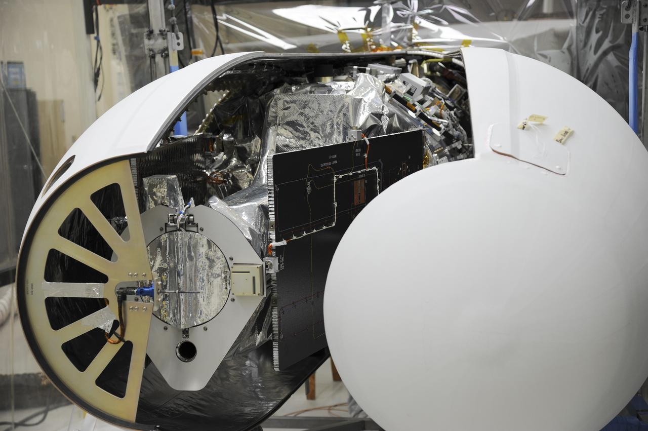 VANDENBERG AFB – Orbital Sciences team members move the second half of the payload fairing before it is placed over NASA's IRIS spacecraft. The fairing connects to the nose of the Orbital Sciences Pegasus XL rocket that will lift the solar observatory into orbit in June. The work is taking place in a hangar at Vandenberg Air Force Base where IRIS, short for Interface Region Imaging Spectrograph, is being prepared for launch on a Pegasus XL rocket. Scheduled for launch from Vandenberg June 26, IRIS will open a new window of discovery by tracing the flow of energy and plasma through the chromospheres and transition region into the sun’s corona using spectrometry and imaging. IRIS fills a crucial gap in our ability to advance studies of the sun-to-Earth connection by tracing the flow of energy and plasma through the foundation of the corona and the region around the sun known as the heliosphere. Photo credit: NASA/Tony Vauclin