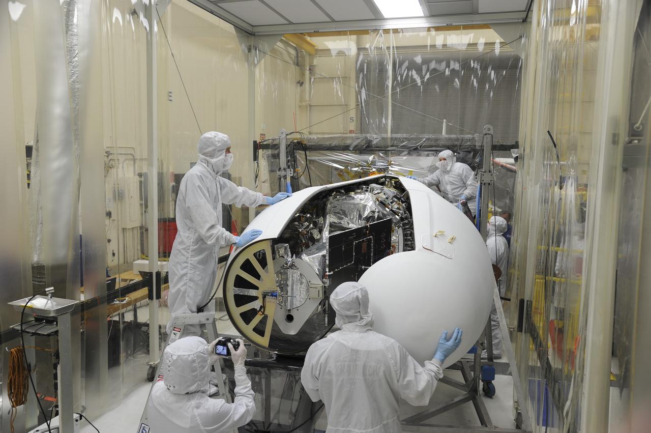 VANDENBERG AFB – Orbital Sciences engineers connect the payload fairing over NASA's IRIS spacecraft. The fairing connects to the nose of the Orbital Sciences Pegasus XL rocket that will lift the solar observatory into orbit in June. The work is taking place in a hangar at Vandenberg Air Force Base where IRIS, short for Interface Region Imaging Spectrograph, is being prepared for launch on a Pegasus XL rocket. Scheduled for launch from Vandenberg June 26, IRIS will open a new window of discovery by tracing the flow of energy and plasma through the chromospheres and transition region into the sun’s corona using spectrometry and imaging. IRIS fills a crucial gap in our ability to advance studies of the sun-to-Earth connection by tracing the flow of energy and plasma through the foundation of the corona and the region around the sun known as the heliosphere. Photo credit: NASA/Tony Vauclin