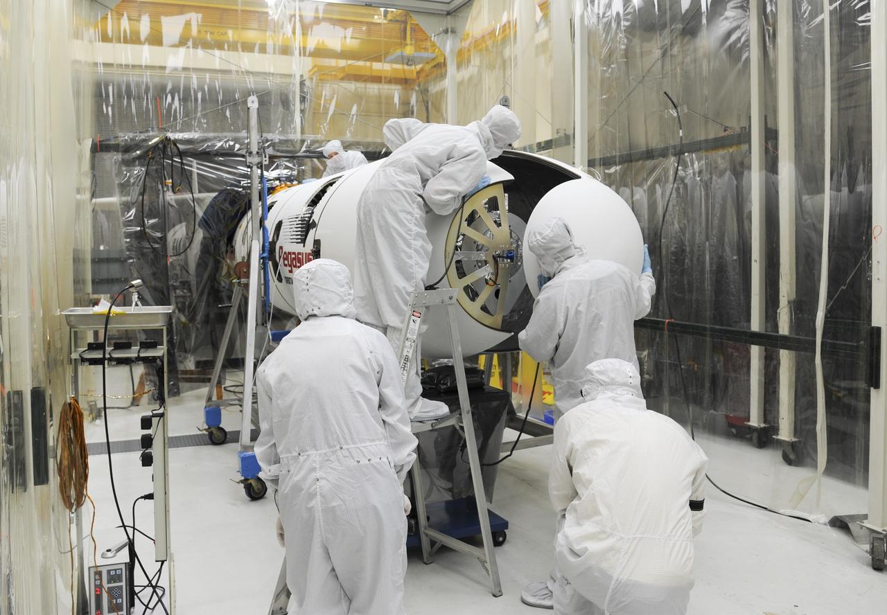 VANDENBERG AFB – Orbital Sciences engineers connect the payload fairing over NASA's IRIS spacecraft. The fairing connects to the nose of the Orbital Sciences Pegasus XL rocket that will lift the solar observatory into orbit in June. The work is taking place in a hangar at Vandenberg Air Force Base where IRIS, short for Interface Region Imaging Spectrograph, is being prepared for launch on a Pegasus XL rocket. Scheduled for launch from Vandenberg June 26, IRIS will open a new window of discovery by tracing the flow of energy and plasma through the chromospheres and transition region into the sun’s corona using spectrometry and imaging. IRIS fills a crucial gap in our ability to advance studies of the sun-to-Earth connection by tracing the flow of energy and plasma through the foundation of the corona and the region around the sun known as the heliosphere. Photo credit: NASA/Tony Vauclin