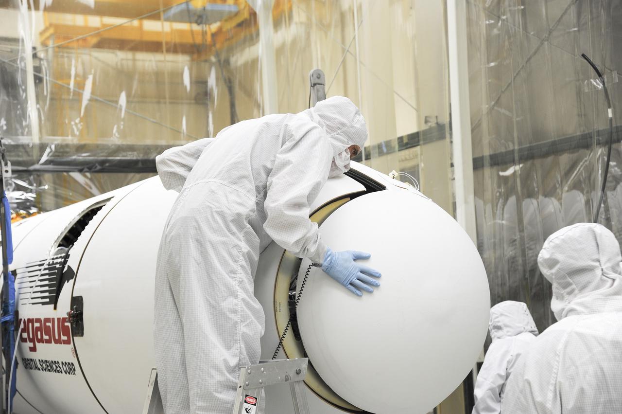 VANDENBERG AFB – Orbital Sciences engineers connect the payload fairing over NASA's IRIS spacecraft. The fairing connects to the nose of the Orbital Sciences Pegasus XL rocket that will lift the solar observatory into orbit in June. The work is taking place in a hangar at Vandenberg Air Force Base where IRIS, short for Interface Region Imaging Spectrograph, is being prepared for launch on a Pegasus XL rocket. Scheduled for launch from Vandenberg June 26, IRIS will open a new window of discovery by tracing the flow of energy and plasma through the chromospheres and transition region into the sun’s corona using spectrometry and imaging. IRIS fills a crucial gap in our ability to advance studies of the sun-to-Earth connection by tracing the flow of energy and plasma through the foundation of the corona and the region around the sun known as the heliosphere. Photo credit: NASA/Tony Vauclin