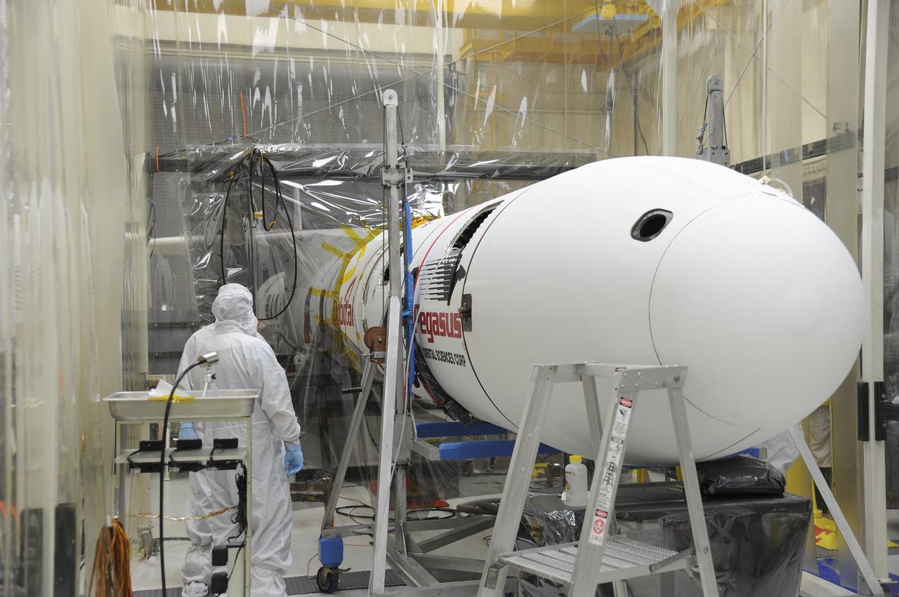 VANDENBERG AFB – Orbital Sciences engineers monitor the connection of the payload fairing over NASA's IRIS spacecraft. The fairing connects to the nose of the Orbital Sciences Pegasus XL rocket that will lift the solar observatory into orbit in June. The work is taking place in a hangar at Vandenberg Air Force Base where IRIS, short for Interface Region Imaging Spectrograph, is being prepared for launch on a Pegasus XL rocket. Scheduled for launch from Vandenberg June 26, IRIS will open a new window of discovery by tracing the flow of energy and plasma through the chromospheres and transition region into the sun’s corona using spectrometry and imaging. IRIS fills a crucial gap in our ability to advance studies of the sun-to-Earth connection by tracing the flow of energy and plasma through the foundation of the corona and the region around the sun known as the heliosphere. Photo credit: NASA/Tony Vauclin