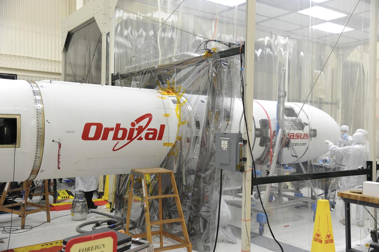 VANDENBERG AFB – Orbital Sciences team engineers monitor the connection of the payload fairing over NASA's IRIS spacecraft. The fairing connects to the nose of the Orbital Sciences Pegasus XL rocket that will lift the solar observatory into orbit in June. The work is taking place in a hangar at Vandenberg Air Force Base where IRIS, short for Interface Region Imaging Spectrograph, is being prepared for launch on a Pegasus XL rocket. Scheduled for launch from Vandenberg June 26, IRIS will open a new window of discovery by tracing the flow of energy and plasma through the chromospheres and transition region into the sun’s corona using spectrometry and imaging. IRIS fills a crucial gap in our ability to advance studies of the sun-to-Earth connection by tracing the flow of energy and plasma through the foundation of the corona and the region around the sun known as the heliosphere. Photo credit: NASA/Tony Vauclin