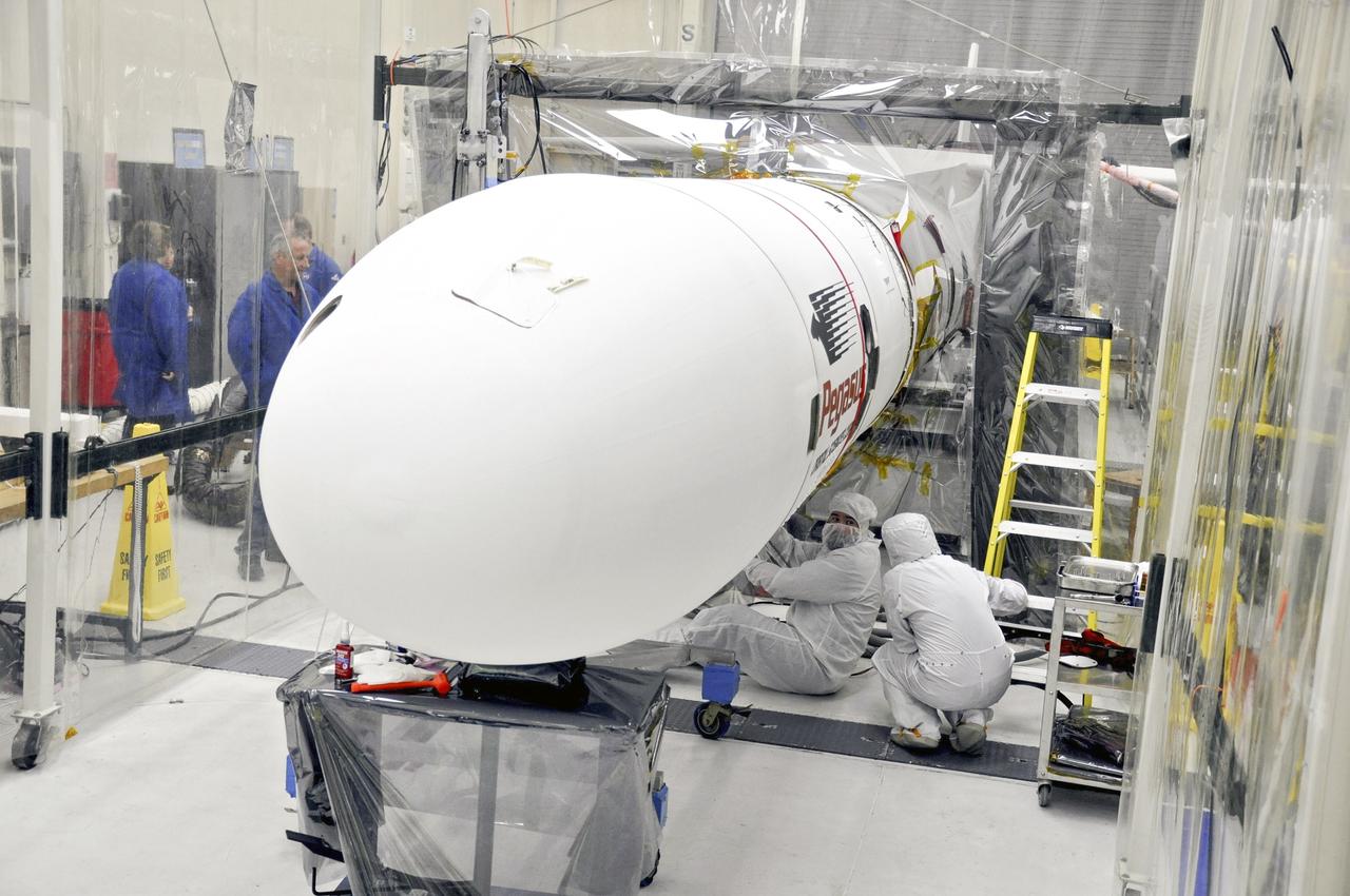 VANDENBERG AFB – Engineers connect the payload fairing over NASA's IRIS spacecraft. The fairing connects to the nose of the Orbital Sciences Pegasus XL rocket that will lift the solar observatory into orbit in June. The work is taking place in a hangar at Vandenberg Air Force Base where IRIS, short for Interface Region Imaging Spectrograph, is being prepared for launch on a Pegasus XL rocket. Scheduled for launch from Vandenberg June 26, IRIS will open a new window of discovery by tracing the flow of energy and plasma through the chromospheres and transition region into the sun’s corona using spectrometry and imaging. IRIS fills a crucial gap in our ability to advance studies of the sun-to-Earth connection by tracing the flow of energy and plasma through the foundation of the corona and the region around the sun known as the heliosphere. Photo credit: NASA/Randy Beaudoin