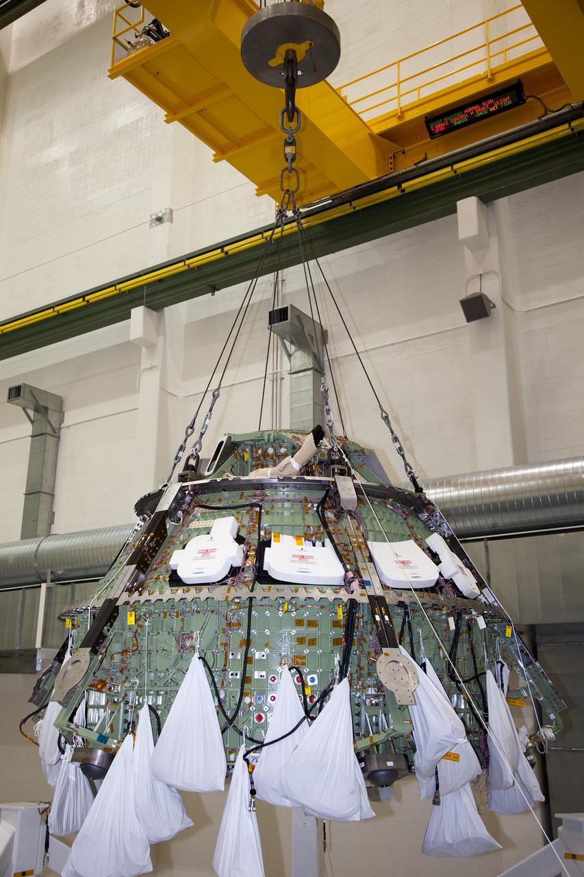 CAPE CANAVERAL, Fla. – Inside the Operations and Checkout Building high bay at NASA’s Kennedy Space Center in Florida, a crane lifts the Orion crew module out of a special test stand. Lockheed Martin Space Systems and NASA engineers performed a series of static load tests on Orion that simulated the massive loads the spacecraft would experience during its mission.    Orion is the exploration spacecraft designed to carry crews to space beyond low Earth orbit. It will provide emergency abort capability, sustain the crew during the space travel and provide safe re-entry from deep space return velocities. Orion’s first unpiloted test flight, Exploration Flight Test 1, is scheduled to launch in 2014 atop a Delta IV rocket. A second uncrewed flight test is scheduled for 2017 on NASA’s Space Launch System rocket. For more information, visit http://www.nasa.gov/orion. Photo credit: NASA/Daniel Casper