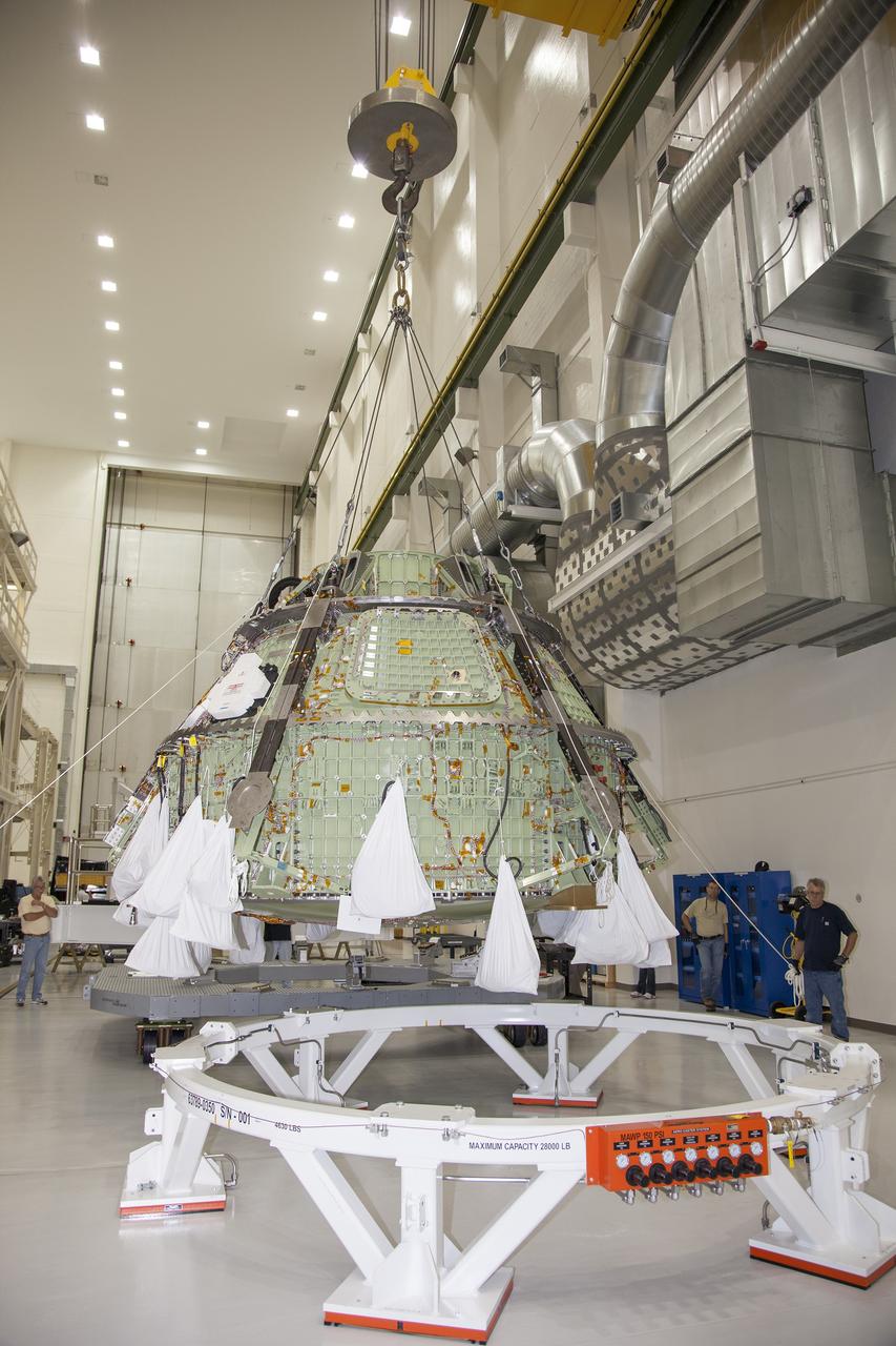 CAPE CANAVERAL, Fla. – Inside the Operations and Checkout Building high bay at NASA’s Kennedy Space Center in Florida, a crane is used to lower the Orion crew module onto a work stand after it was lifted out of a special test stand. Lockheed Martin Space Systems and NASA engineers performed a series of static load tests on Orion that simulated the massive loads the spacecraft would experience during its mission. Orion is the exploration spacecraft designed to carry crews to space beyond low Earth orbit. It will provide emergency abort capability, sustain the crew during the space travel and provide safe re-entry from deep space return velocities. Orion’s first unpiloted test flight, Exploration Flight Test 1, is scheduled to launch in 2014 atop a Delta IV rocket. A second uncrewed flight test is scheduled for 2017 on NASA’s Space Launch System rocket. For more information, visit http://www.nasa.gov/orion. Photo credit: NASA/Daniel Casper
