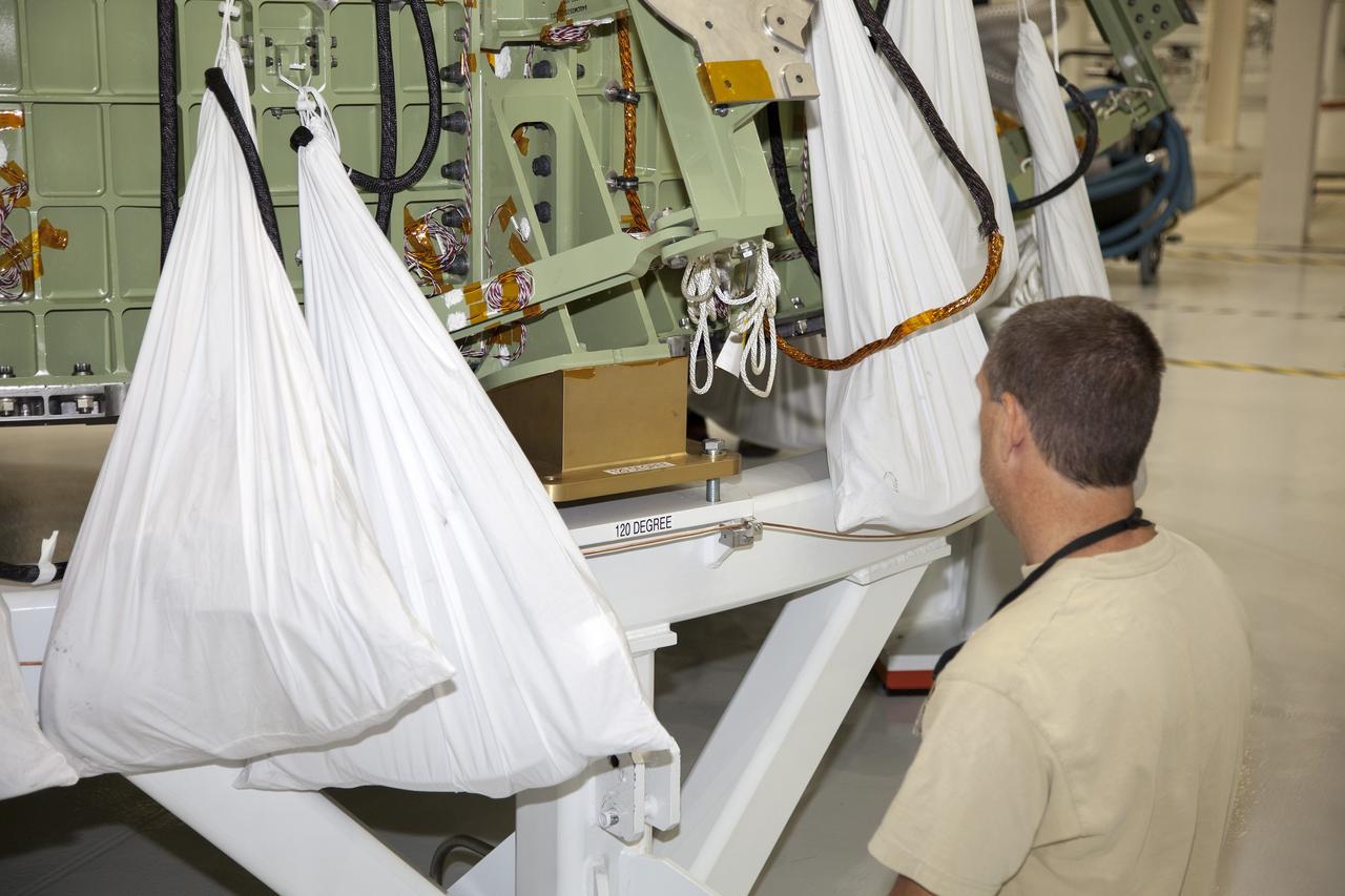 CAPE CANAVERAL, Fla. –Inside the Operations and Checkout Building high bay at NASA’s Kennedy Space Center in Florida, a technician monitors the progress as a crane lowers the Orion crew module onto a work stand after it was lifted out of a special test stand. Lockheed Martin Space Systems and NASA engineers performed a series of static load tests on Orion that simulated the massive loads the spacecraft would experience during its mission. Orion is the exploration spacecraft designed to carry crews to space beyond low Earth orbit. It will provide emergency abort capability, sustain the crew during the space travel and provide safe re-entry from deep space return velocities. Orion’s first unpiloted test flight, Exploration Flight Test 1, is scheduled to launch in 2014 atop a Delta IV rocket. A second uncrewed flight test is scheduled for 2017 on NASA’s Space Launch System rocket. For more information, visit http://www.nasa.gov/orion. Photo credit: NASA/Daniel Casper