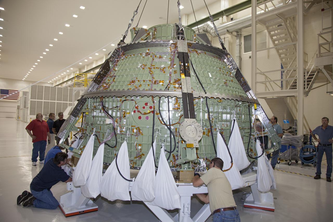CAPE CANAVERAL, Fla. – Inside the Operations and Checkout Building high bay at NASA’s Kennedy Space Center in Florida, technicians help secure the Orion crew module onto a work stand after it was lifted out of a special test stand. Lockheed Martin Space Systems and NASA engineers performed a series of static load tests on Orion that simulated the massive loads the spacecraft would experience during its mission. Orion is the exploration spacecraft designed to carry crews to space beyond low Earth orbit. It will provide emergency abort capability, sustain the crew during the space travel and provide safe re-entry from deep space return velocities. Orion’s first unpiloted test flight, Exploration Flight Test 1, is scheduled to launch in 2014 atop a Delta IV rocket. A second uncrewed flight test is scheduled for 2017 on NASA’s Space Launch System rocket. For more information, visit http://www.nasa.gov/orion. Photo credit: NASA/Daniel Casper