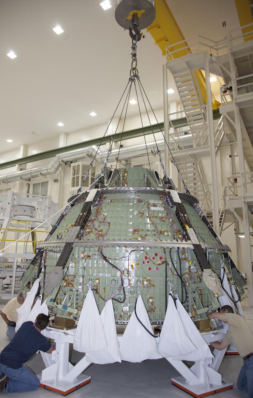 CAPE CANAVERAL, Fla. – Inside the Operations and Checkout Building high bay at NASA’s Kennedy Space Center in Florida, technicians help secure the Orion crew module onto a work stand after it was lifted out of a special test stand. Lockheed Martin Space Systems and NASA engineers performed a series of static load tests on Orion that simulated the massive loads the spacecraft would experience during its mission.    Orion is the exploration spacecraft designed to carry crews to space beyond low Earth orbit. It will provide emergency abort capability, sustain the crew during the space travel and provide safe re-entry from deep space return velocities. Orion’s first unpiloted test flight, Exploration Flight Test 1, is scheduled to launch in 2014 atop a Delta IV rocket. A second uncrewed flight test is scheduled for 2017 on NASA’s Space Launch System rocket. For more information, visit http://www.nasa.gov/orion. Photo credit: NASA/Daniel Casper
