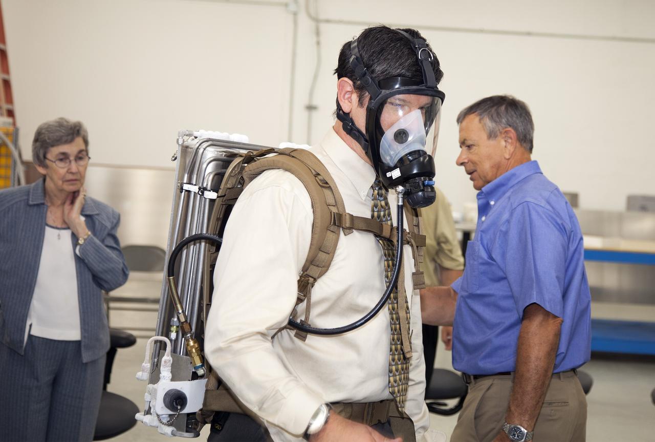 TITUSVILLE, Fla. - NASA Kennedy Space Center Lead Engineer David Bush, center, demos a small liquid-air filled backpack called CryoBA, short for Cryogenic Breathing Apparatus, at BCS Life Support in Titusville, Fla. The CryoBA and a larger Cryogenic Refuge Alternative Supply System, or CryoRASS, are being developed by a Kennedy engineering team in collaboration with The National Institute for Occupational Safety and Health to provide miners with twice the amount of breathable and cooler air than traditional compressed systems. The technology also could be used for commercial applications, such as fire and military rescue operations, as well as NASA's future human spaceflight missions. Photo credit: NASA/Daniel Casper
