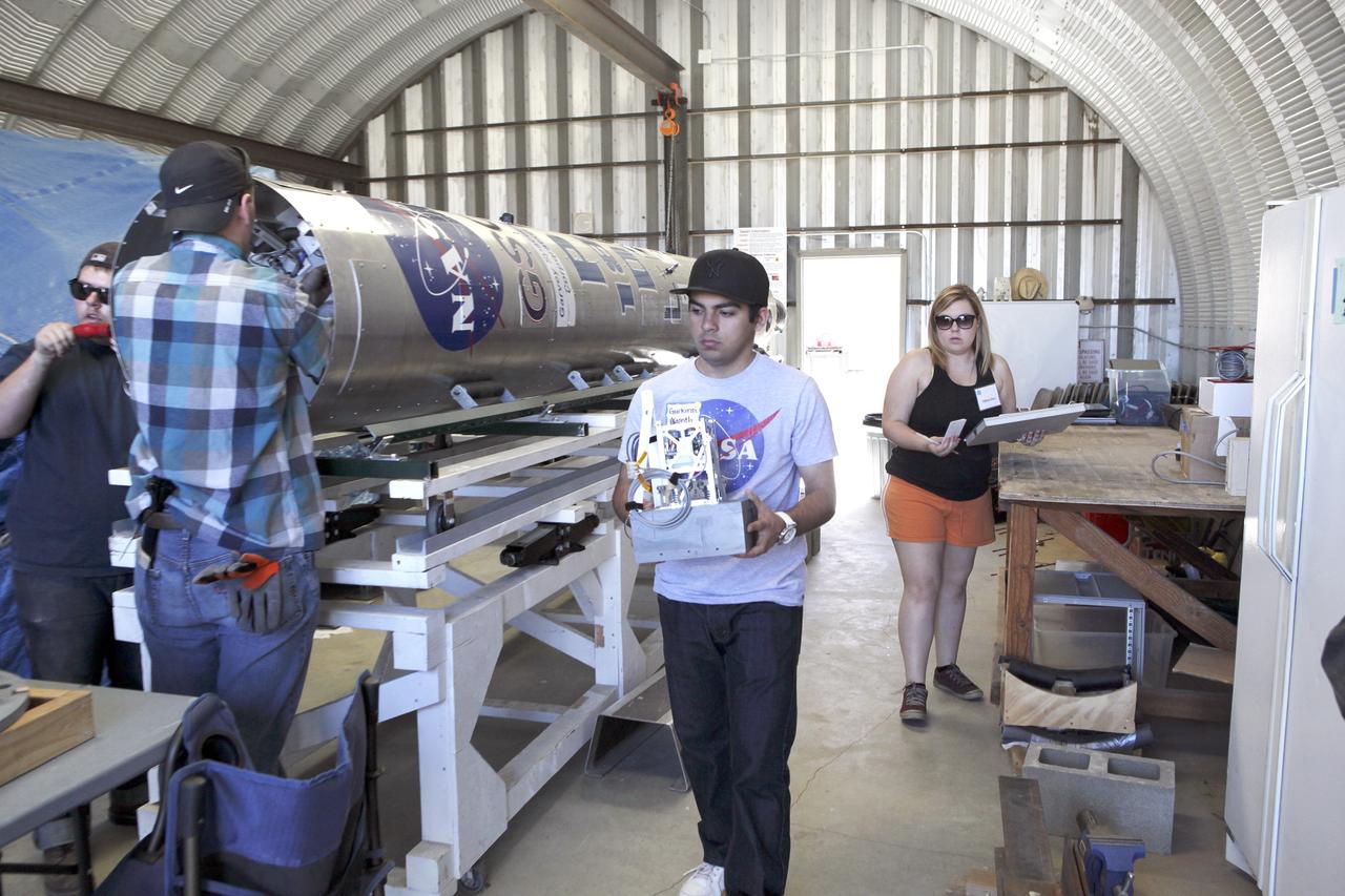 MOJAVE DESERT, Calif. – In the Mojave Desert in California, students and engineers prepare to load the RUBICS-1 payload into the body of the Garvey Spacecraft Corporation's Prospector P-18D rocket for launch June 15 on a high-altitude, suborbital flight. The flight will carry four satellites made from four-inch cube section. Collectively known as CubeSats, the satellites will record shock, vibrations and heat inside the rocket. They will not be released during the test flight, but the results will be used to prove or strengthen their designs before they are carried into orbit in 2014 on a much larger rocket. A new, lightweight carrier is also being tested for use on future missions to deploy the small spacecraft. The flight also is being watched closely as a model for trying out new or off-the-shelf technologies quickly before putting them in the pipeline for use on NASA's largest launchers. Built by several different organizations, including a university, a NASA field center and a high school, the spacecraft are four-inch cubes designed to fly on their own eventually, but will remain firmly attached to the rocket during the upcoming mission. For more information, visit http://www.nasa.gov/mission_pages/smallsats/elana/cubesatlaunchpreview.html Photo credit: NASA/Dimitri Gerondidakis