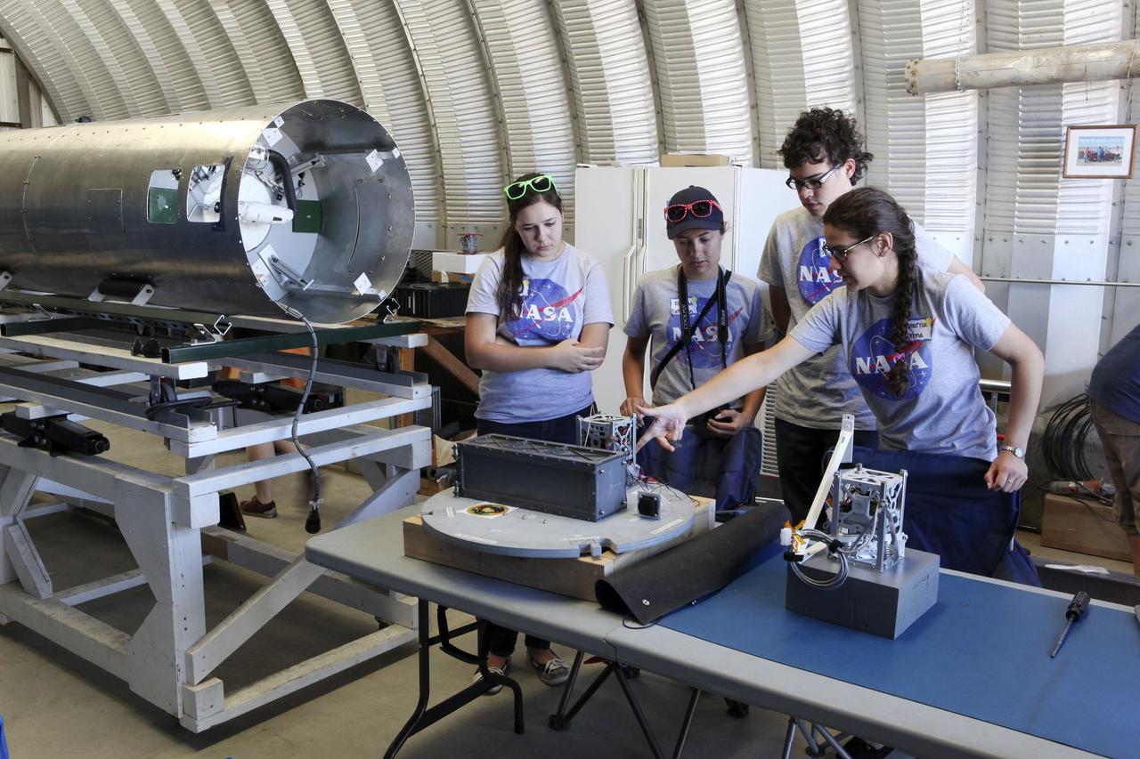 MOJAVE DESERT, Calif. – In the Mojave Desert in California, students and engineers checkout the RUBICS-1 payload into the body of the Garvey Spacecraft Corporation's Prospector P-18D rocket for launch June 15 on a high-altitude, suborbital flight. The flight will carry four satellites made from four-inch cube section. Collectively known as CubeSats, the satellites will record shock, vibrations and heat inside the rocket. They will not be released during the test flight, but the results will be used to prove or strengthen their designs before they are carried into orbit in 2014 on a much larger rocket. A new, lightweight carrier is also being tested for use on future missions to deploy the small spacecraft. The flight also is being watched closely as a model for trying out new or off-the-shelf technologies quickly before putting them in the pipeline for use on NASA's largest launchers. Built by several different organizations, including a university, a NASA field center and a high school, the spacecraft are four-inch cubes designed to fly on their own eventually, but will remain firmly attached to the rocket during the upcoming mission. For more information, visit http://www.nasa.gov/mission_pages/smallsats/elana/cubesatlaunchpreview.html Photo credit: NASA/Dimitri Gerondidakis