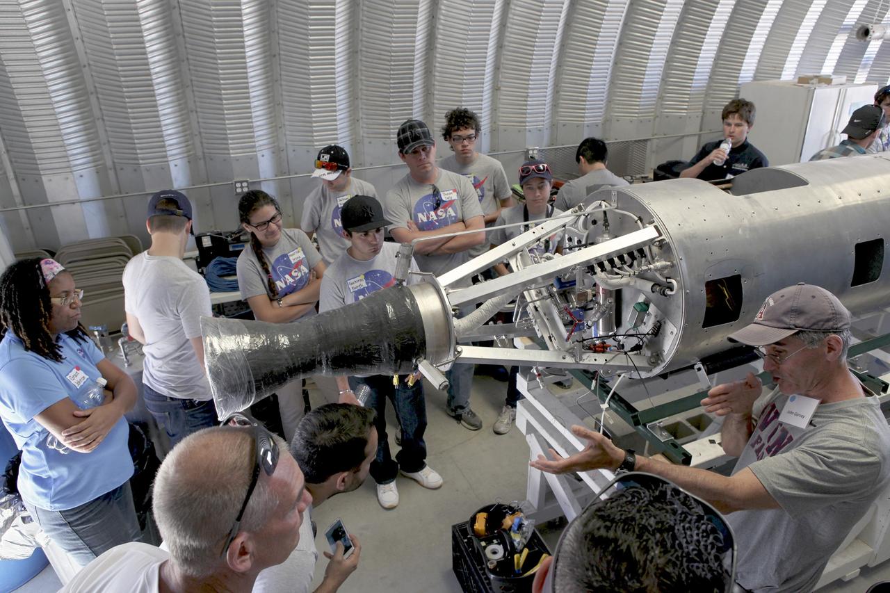 MOJAVE DESERT, Calif. – In the Mojave Desert in California, John Garvey, far right, describes his company's Prospector-18 rocket. Long Beach, Calif.-based Garvey Spacecraft Corp. built the rocket and its engine. Collectively known as CubeSats, the satellites will record shock, vibrations and heat inside the rocket. They will not be released during the test flight, but the results will be used to prove or strengthen their designs before they are carried into orbit in 2014 on a much larger rocket. A new, lightweight carrier is also being tested for use on future missions to deploy the small spacecraft. The flight also is being watched closely as a model for trying out new or off-the-shelf technologies quickly before putting them in the pipeline for use on NASA's largest launchers. Built by several different organizations, including a university, a NASA field center and a high school, the spacecraft are four-inch cubes designed to fly on their own eventually, but will remain firmly attached to the rocket during the upcoming mission. For more information, visit http://www.nasa.gov/mission_pages/smallsats/elana/cubesatlaunchpreview.html Photo credit: NASA/Dimitri Gerondidakis