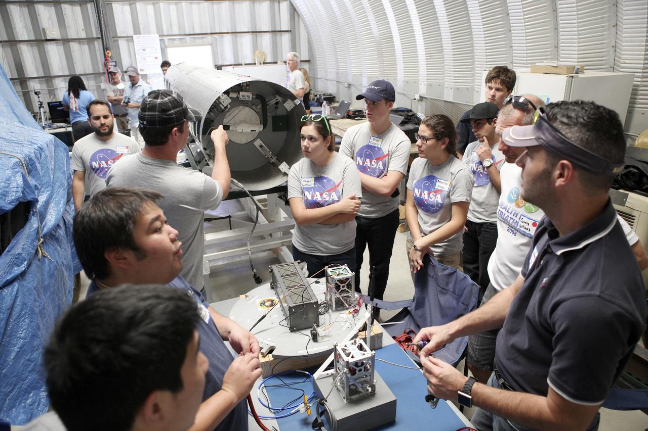 MOJAVE DESERT, Calif. – In the Mojave Desert in California, students and engineers checkout the RUBICS-1 payload into the body of the Garvey Spacecraft Corporation's Prospector P-18D rocket for launch June 15 on a high-altitude, suborbital flight. The flight will carry four satellites made from four-inch cube section. Collectively known as CubeSats, the satellites will record shock, vibrations and heat inside the rocket. They will not be released during the test flight, but the results will be used to prove or strengthen their designs before they are carried into orbit in 2014 on a much larger rocket. A new, lightweight carrier is also being tested for use on future missions to deploy the small spacecraft. The flight also is being watched closely as a model for trying out new or off-the-shelf technologies quickly before putting them in the pipeline for use on NASA's largest launchers. Built by several different organizations, including a university, a NASA field center and a high school, the spacecraft are four-inch cubes designed to fly on their own eventually, but will remain firmly attached to the rocket during the upcoming mission. For more information, visit http://www.nasa.gov/mission_pages/smallsats/elana/cubesatlaunchpreview.html Photo credit: NASA/Dimitri Gerondidakis