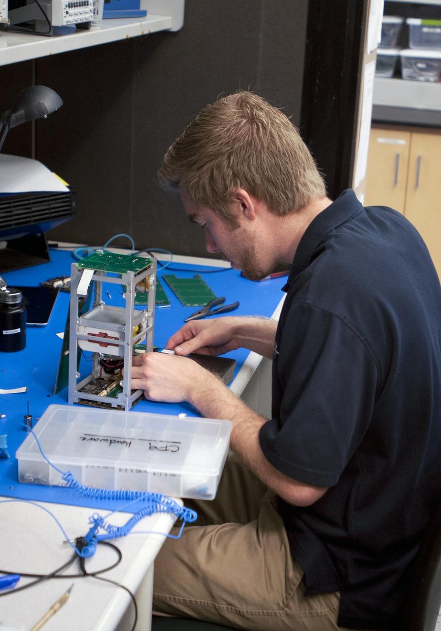 SAN LUIS OBISPO, Calif. – A member of the student launch team for the Polysat works through final checks in the CubeSat lab facility at California Polytechnic Institute, or CalPoly. The payloads, which include sensors and equipment carefully packaged into 4-inch cubes, will ride in the body of a Garvey Spacecraft Corporation's Prospector P-18D rocket during a June 15 launch on a high-altitude, suborbital flight. Collectively known as CubeSats, the satellites will record shock, vibrations and heat inside the rocket. They will not be released during the test flight, but the results will be used to prove or strengthen their designs before they are carried into orbit in 2014 on a much larger rocket. A new, lightweight carrier is also being tested for use on future missions to deploy the small spacecraft. The flight also is being watched closely as a model for trying out new or off-the-shelf technologies quickly before putting them in the pipeline for use on NASA's largest launchers. Built by several different organizations, including a university, a NASA field center and a high school, the spacecraft are four-inch cubes designed to fly on their own eventually, but will remain firmly attached to the rocket during the upcoming mission. For more information, visit http://www.nasa.gov/mission_pages/smallsats/elana/cubesatlaunchpreview.html Photo credit: VAFB/Kathi Peoples