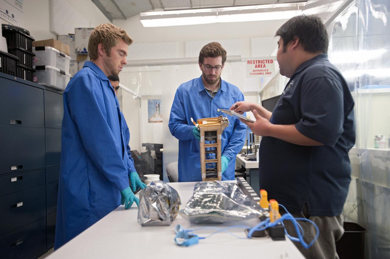 SAN LUIS OBISPO, Calif. – Roland Coelho, right, CalPoly program lead, and members of the student launch team for the Polysat works through final checks in the CubeSat lab facility at California Polytechnic Institute, or CalPoly. The payload, which includes sensors and equipment carefully packaged into 4-inch cube sections, will ride in the body of a Garvey Spacecraft Corporation's Prospector P-18D rocket during a June 15 launch on a high-altitude, suborbital flight. Known as a CubeSat, the satellite will record shock, vibrations and heat inside the rocket. It will not be released during the test flight, but the results will be used to prove or strengthen their designs before they are carried into orbit in 2014 on a much larger rocket. A new, lightweight carrier is also being tested for use on future missions to deploy the small spacecraft. The flight also is being watched closely as a model for trying out new or off-the-shelf technologies quickly before putting them in the pipeline for use on NASA's largest launchers. Built by several different organizations, including a university, a NASA field center and a high school, the spacecraft are four-inch cubes designed to fly on their own eventually, but will remain firmly attached to the rocket during the upcoming mission. For more information, visit http://www.nasa.gov/mission_pages/smallsats/elana/cubesatlaunchpreview.html Photo credit: VAFB/Kathi Peoples