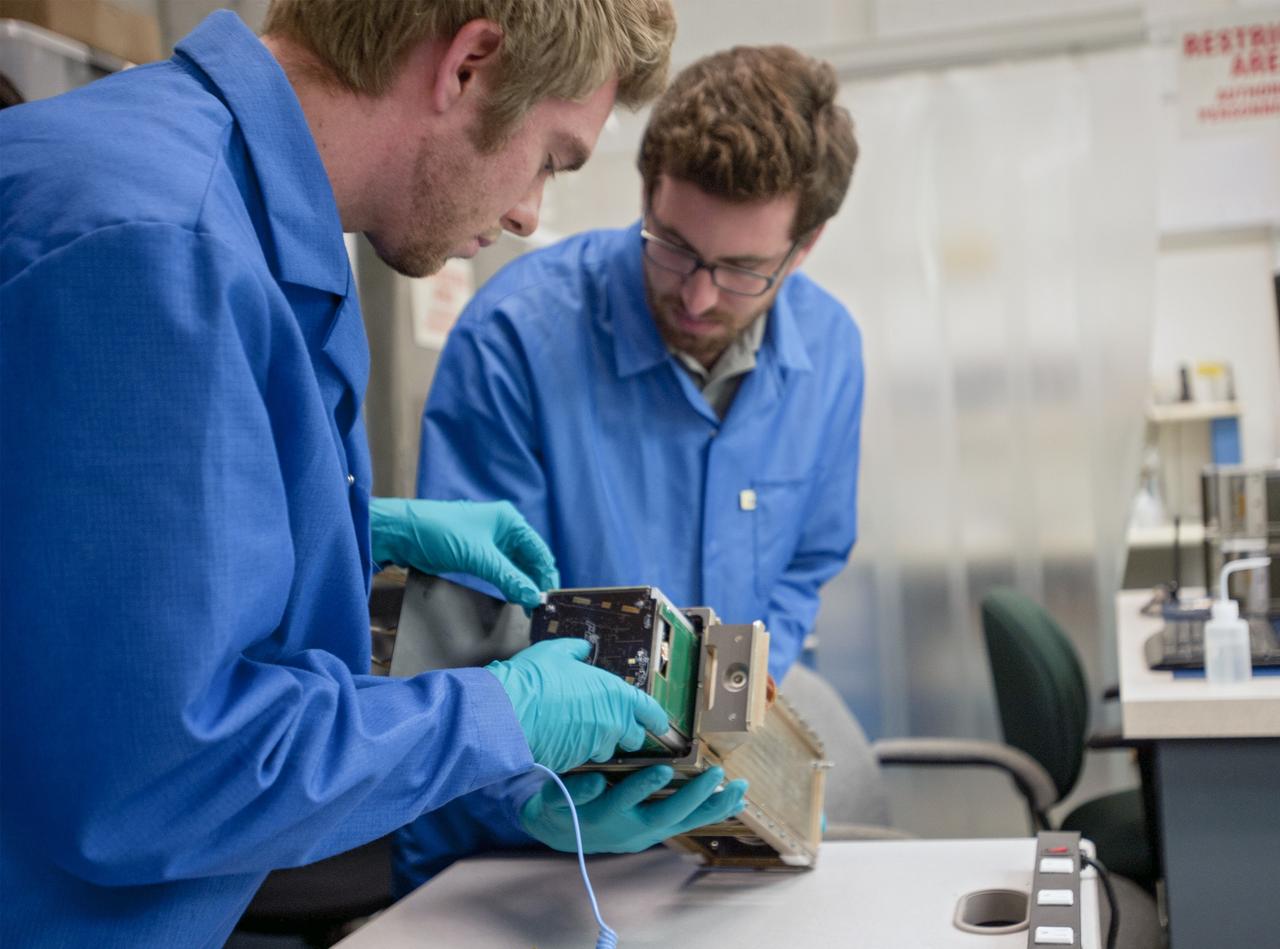 KSC-2013-2721 – SAN LUIS OBISPO, Calif. –Members of the student launch team load a payload into a Poly Picosatellite Orbital Dispensor, or P-Pod nanolauncher/carrier in the CubeSat lab facility at California Polytechnic Institute, or CalPoly. The payload, which includes sensors and equipment carefully packaged into 4-inch cube sections, will ride in the body of a Garvey Spacecraft Corporation's Prospector P-18D rocket during a June 15 launch on a high-altitude, suborbital flight. Known as a CubeSat, the satellite will record shock, vibrations and heat inside the rocket. It will not be released during the test flight, but the results will be used to prove or strengthen their designs before they are carried into orbit in 2014 on a much larger rocket. Also, a new launcher/carrier of a lightweight design also is being tested for use on future missions to deploy the small spacecraft. The flight also is being watched closely as a model for trying out new or off-the-shelf technologies quickly before putting them in the pipeline for use on NASA's largest launchers. Built by several different organizations, including a university, a NASA field center and a high school, the spacecraft are four-inch cubes designed to fly on their own eventually, but will remain firmly attached to the rocket during the upcoming mission. For more information, visit http://www.nasa.gov/mission_pages/smallsats/elana/cubesatlaunchpreview.html Photo credit: VAFB/Kathi Peoples