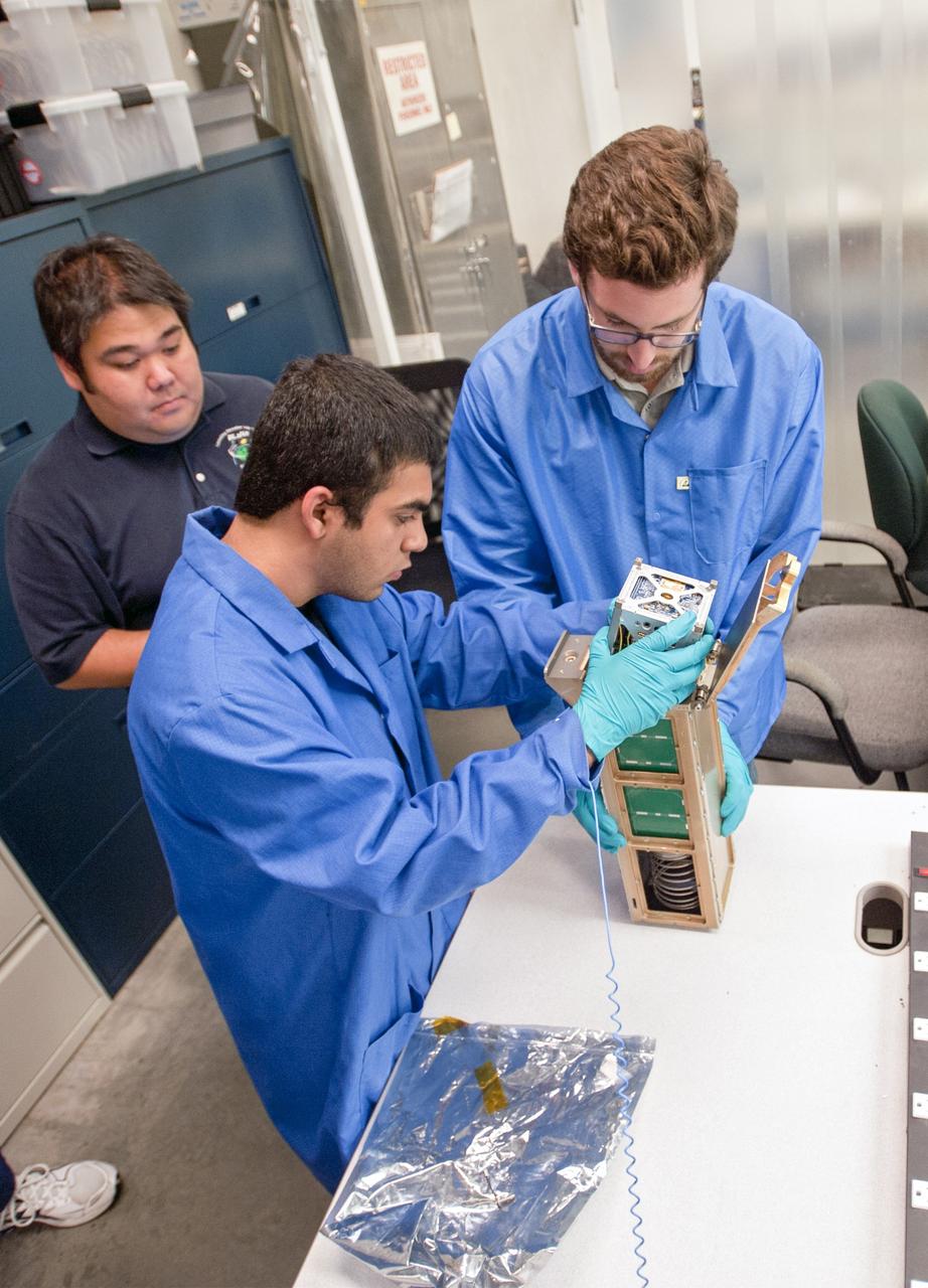 SAN LUIS OBISPO, Calif. – Roland Coelho, third from left, CalPoly program lead, and members of the student launch team load a payload into a Poly Picosatellite Orbital Dispensor, or P-Pod nanolauncher/carrier in the CubeSat lab facility at California Polytechnic Institute, or CalPoly. The payload, which includes sensors and equipment carefully packaged into 4-inch cube sections, will ride in the body of a Garvey Spacecraft Corporation's Prospector P-18D rocket during a June 15 launch on a high-altitude, suborbital flight. Known as a CubeSat, the satellite will record shock, vibrations and heat inside the rocket. It will not be released during the test flight, but the results will be used to prove or strengthen their designs before they are carried into orbit in 2014 on a much larger rocket. Also, a new launcher/carrier of a lightweight design also is being tested for use on future missions to deploy the small spacecraft. The flight also is being watched closely as a model for trying out new or off-the-shelf technologies quickly before putting them in the pipeline for use on NASA's largest launchers. Built by several different organizations, including a university, a NASA field center and a high school, the spacecraft are four-inch cubes designed to fly on their own eventually, but will remain firmly attached to the rocket during the upcoming mission. For more information, visit http://www.nasa.gov/mission_pages/smallsats/elana/cubesatlaunchpreview.html Photo credit: VAFB/Kathi Peoples