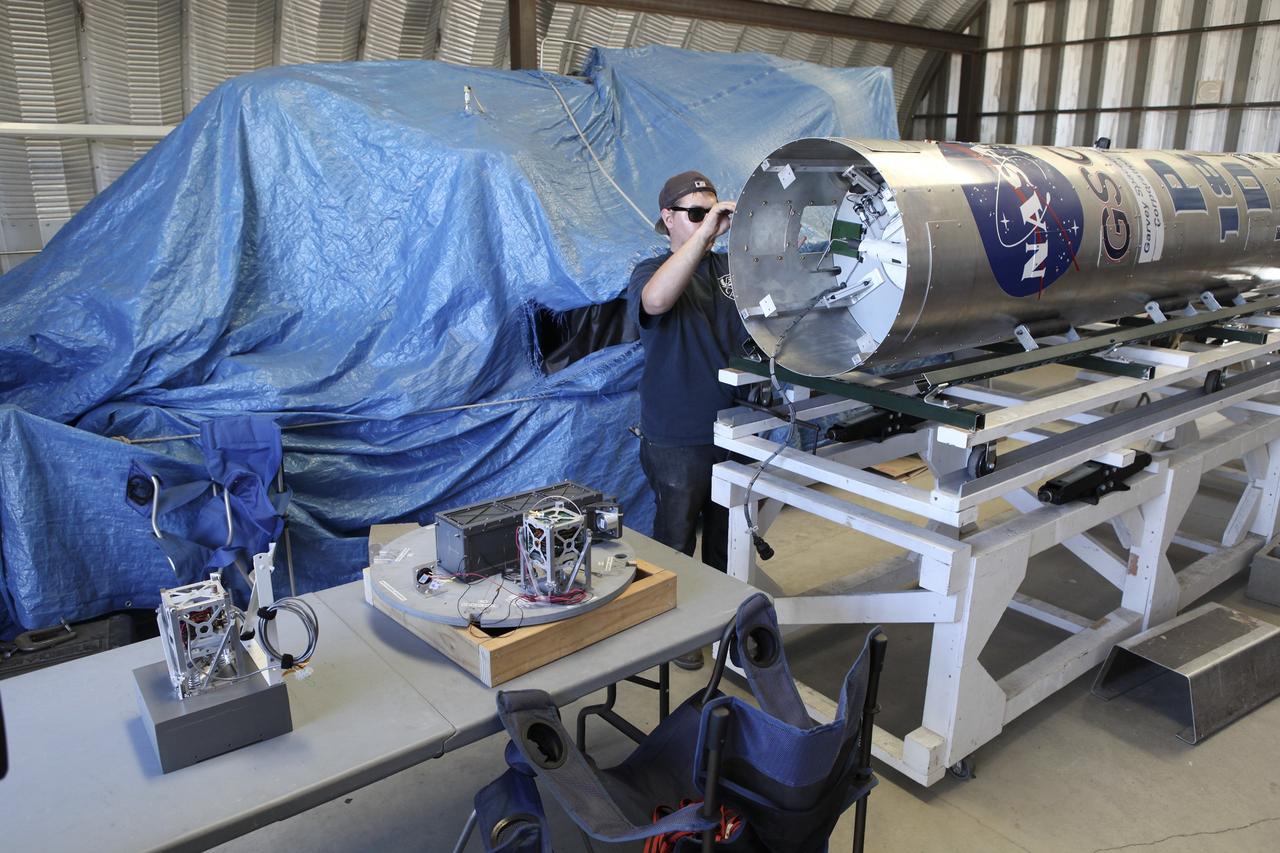 MOJAVE DESERT, Calif. – In the Mojave Desert in California, a student checks out the Garvey Spacecraft Corporation's Prospector P-18D rocket scheduled for launch June 15 with the RUBICS-1 payload on a high-altitude, suborbital flight. The rocket will carry four satellites made from four-inch cube section. Collectively known as CubeSats, the satellites will record shock, vibrations and heat inside the rocket. They will not be released during the test flight, but the results will be used to prove or strengthen their designs before they are carried into orbit in 2014 on a much larger rocket. A new, lightweight carrier is also being tested for use on future missions to deploy the small spacecraft. The flight also is being watched closely as a model for trying out new or off-the-shelf technologies quickly before putting them in the pipeline for use on NASA's largest launchers. Built by several different organizations, including a university, a NASA field center and a high school, the spacecraft are four-inch cubes designed to fly on their own eventually, but will remain firmly attached to the rocket during the upcoming mission. For more information, visit http://www.nasa.gov/mission_pages/smallsats/elana/cubesatlaunchpreview.html Photo credit: NASA/Dimitri Gerondidakis
