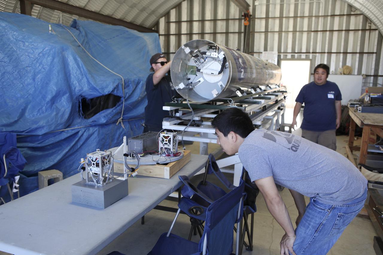 MOJAVE DESERT, Calif. – In the Mojave Desert in California, students and engineers checkout the RUBICS-1 payload which will be placed into the body of the Garvey Spacecraft Corporation's Prospector P-18D rocket for launch June 15 on a high-altitude, suborbital flight. The flight will carry four satellites made from four-inch cube section. Collectively known as CubeSats, the satellites will record shock, vibrations and heat inside the rocket. They will not be released during the test flight, but the results will be used to prove or strengthen their designs before they are carried into orbit in 2014 on a much larger rocket. A new, lightweight carrier is also being tested for use on future missions to deploy the small spacecraft. The flight also is being watched closely as a model for trying out new or off-the-shelf technologies quickly before putting them in the pipeline for use on NASA's largest launchers. Built by several different organizations, including a university, a NASA field center and a high school, the spacecraft are four-inch cubes designed to fly on their own eventually, but will remain firmly attached to the rocket during the upcoming mission. For more information, visit http://www.nasa.gov/mission_pages/smallsats/elana/cubesatlaunchpreview.html Photo credit: NASA/Dimitri Gerondidakis