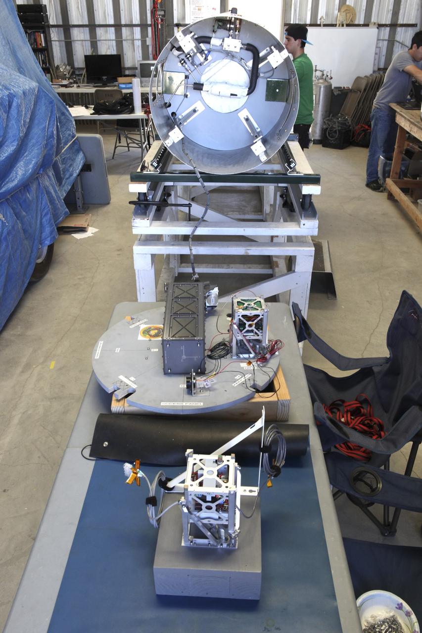 MOJAVE DESERT, Calif. – In the Mojave Desert in California, the student-designed RUBICS-1 payload is in the foreground as students and engineers checkout the into the body of the Garvey Spacecraft Corporation's Prospector P-18D rocket set for launch June 15 on a high-altitude, suborbital flight. The flight will carry four satellites made from four-inch cube section. Collectively known as CubeSats, the satellites will record shock, vibrations and heat inside the rocket. They will not be released during the test flight, but the results will be used to prove or strengthen their designs before they are carried into orbit in 2014 on a much larger rocket. A new, lightweight carrier is also being tested for use on future missions to deploy the small spacecraft. The flight also is being watched closely as a model for trying out new or off-the-shelf technologies quickly before putting them in the pipeline for use on NASA's largest launchers. Built by several different organizations, including a university, a NASA field center and a high school, the spacecraft are four-inch cubes designed to fly on their own eventually, but will remain firmly attached to the rocket during the upcoming mission. For more information, visit http://www.nasa.gov/mission_pages/smallsats/elana/cubesatlaunchpreview.html Photo credit: NASA/Dimitri Gerondidakis
