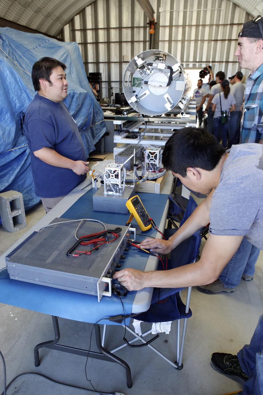 MOJAVE DESERT, Calif. – In the Mojave Desert in California, students and engineers checkout the RUBICS-1 payload which will be placed into the body of the Garvey Spacecraft Corporation's Prospector P-18D rocket for launch June 15 on a high-altitude, suborbital flight. The flight will carry four satellites made from four-inch cube section. Collectively known as CubeSats, the satellites will record shock, vibrations and heat inside the rocket. They will not be released during the test flight, but the results will be used to prove or strengthen their designs before they are carried into orbit in 2014 on a much larger rocket. A new, lightweight carrier is also being tested for use on future missions to deploy the small spacecraft. The flight also is being watched closely as a model for trying out new or off-the-shelf technologies quickly before putting them in the pipeline for use on NASA's largest launchers. Built by several different organizations, including a university, a NASA field center and a high school, the spacecraft are four-inch cubes designed to fly on their own eventually, but will remain firmly attached to the rocket during the upcoming mission. For more information, visit http://www.nasa.gov/mission_pages/smallsats/elana/cubesatlaunchpreview.html Photo credit: NASA/Dimitri Gerondidakis