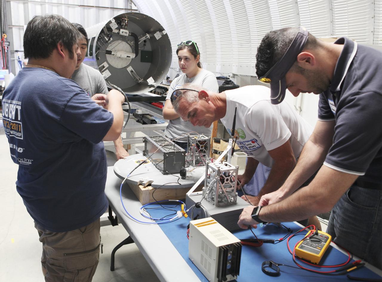 MOJAVE DESERT, Calif. – In the Mojave Desert in California, students and engineers checkout the RUBICS-1 payload which will be placed into the body of the Garvey Spacecraft Corporation's Prospector P-18D rocket for launch June 15 on a high-altitude, suborbital flight. The flight will carry four satellites made from four-inch cube section. Collectively known as CubeSats, the satellites will record shock, vibrations and heat inside the rocket. They will not be released during the test flight, but the results will be used to prove or strengthen their designs before they are carried into orbit in 2014 on a much larger rocket. A new, lightweight carrier is also being tested for use on future missions to deploy the small spacecraft. The flight also is being watched closely as a model for trying out new or off-the-shelf technologies quickly before putting them in the pipeline for use on NASA's largest launchers. Built by several different organizations, including a university, a NASA field center and a high school, the spacecraft are four-inch cubes designed to fly on their own eventually, but will remain firmly attached to the rocket during the upcoming mission. For more information, visit http://www.nasa.gov/mission_pages/smallsats/elana/cubesatlaunchpreview.html Photo credit: NASA/Dimitri Gerondidakis