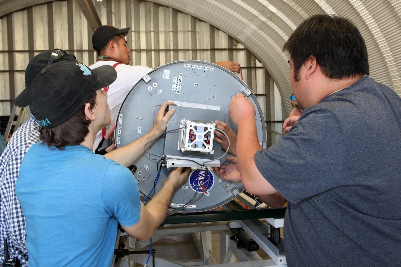 MOJAVE DESERT, Calif. – In the Mojave Desert in California, students and engineers checkout the Garvey Spacecraft Corporation's Prospector P-18D rocket. The rocket is scheduled for launch June 15 with the RUBICS-1 payload on a high-altitude, suborbital flight. The rocket will carry four satellites made from four-inch cube sections. Collectively known as CubeSats, the satellites will record shock, vibrations and heat inside the rocket. They will not be released during the test flight, but the results will be used to prove or strengthen their designs before they are carried into orbit in 2014 on a much larger rocket. A new, lightweight carrier is also being tested for use on future missions to deploy the small spacecraft. The flight also is being watched closely as a model for trying out new or off-the-shelf technologies quickly before putting them in the pipeline for use on NASA's largest launchers. Built by several different organizations, including a university, a NASA field center and a high school, the spacecraft are four-inch cubes designed to fly on their own eventually, but will remain firmly attached to the rocket during the upcoming mission. For more information, visit http://www.nasa.gov/mission_pages/smallsats/elana/cubesatlaunchpreview.html Photo credit: NASA/Dimitri Gerondidakis