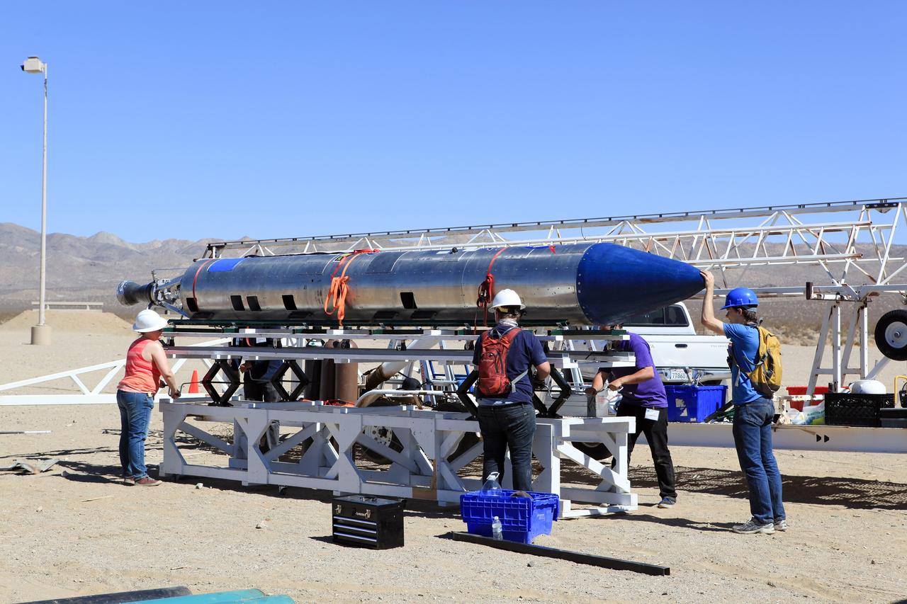 MOJAVE DESERT, Calif. – In the Mojave Desert in California, students and engineers checkout the Garvey Spacecraft Corporation's Prospector P-18D rocket at the Friends of Amateur Rocketry launch site. The rocket is scheduled for launch June 15 with the RUBICS-1 payload on a high-altitude, suborbital mission. The rocket will carry four satellites made from four-inch cube sections. Collectively known as CubeSats, the satellites will record shock, vibrations and heat inside the rocket. They will not be released during the test flight, but the results will be used to prove or strengthen their designs before they are carried into orbit in 2014 on a much larger rocket. A new, lightweight carrier is also being tested for use on future missions to deploy the small spacecraft. The flight also is being watched closely as a model for trying out new or off-the-shelf technologies quickly before putting them in the pipeline for use on NASA's largest launchers. Built by several different organizations, including a university, a NASA field center and a high school, the spacecraft are four-inch cubes designed to fly on their own eventually, but will remain firmly attached to the rocket during the upcoming mission. For more information, visit http://www.nasa.gov/mission_pages/smallsats/elana/cubesatlaunchpreview.html Photo credit: NASA/Dimitri Gerondidakis