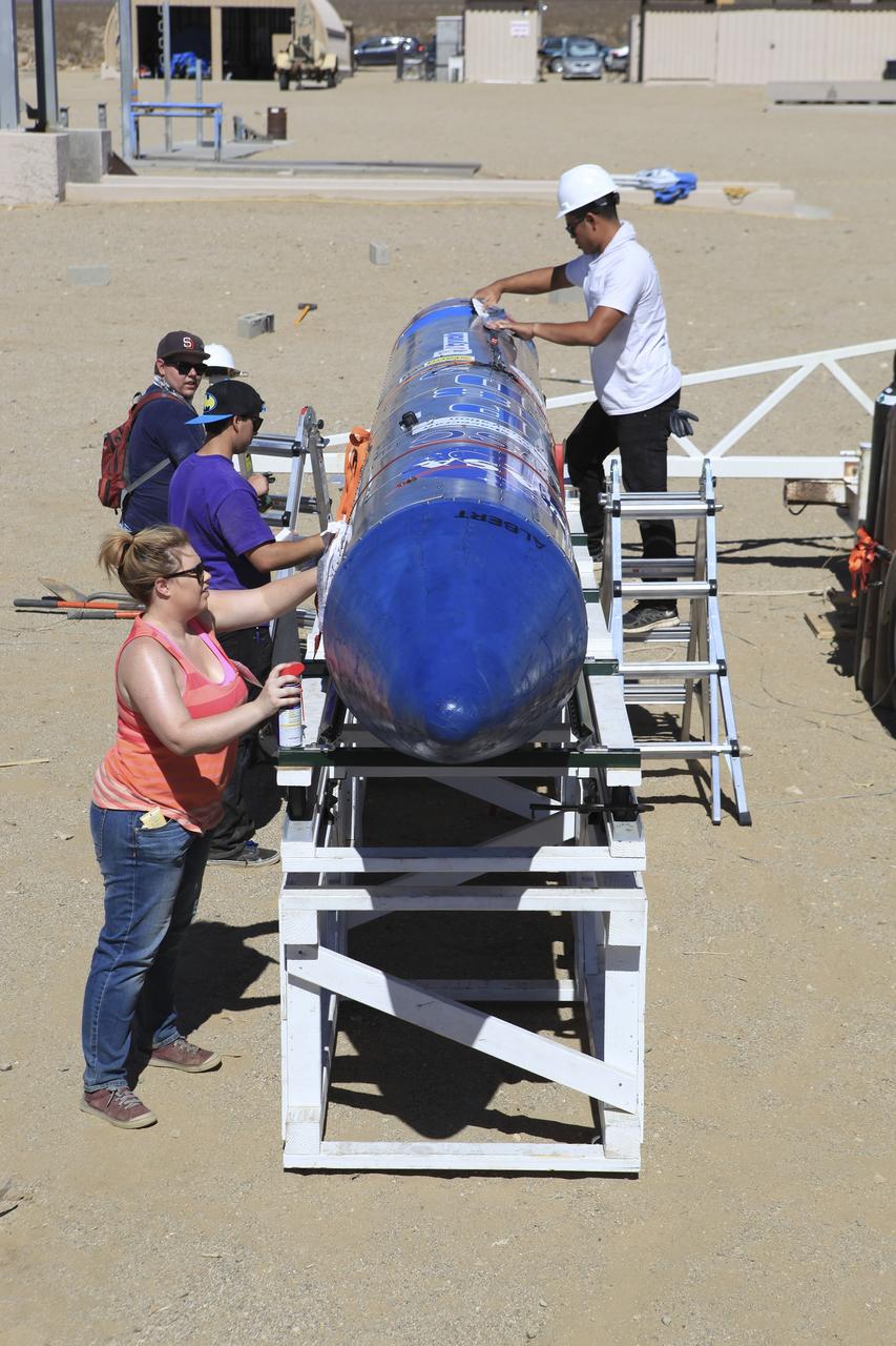 MOJAVE DESERT, Calif. – In the Mojave Desert in California, students and engineers checkout the Garvey Spacecraft Corporation's Prospector P-18D rocket at the Friends of Amateur Rocketry launch site. The rocket is scheduled for flight June 15 with the RUBICS-1 payload on a high-altitude, suborbital flight. The rocket will carry four satellites made from four-inch cube sections. Collectively known as CubeSats, the satellites will record shock, vibrations and heat inside the rocket. They will not be released during the test flight, but the results will be used to prove or strengthen their designs before they are carried into orbit in 2014 on a much larger rocket. A new, lightweight carrier is also being tested for use on future missions to deploy the small spacecraft. The flight also is being watched closely as a model for trying out new or off-the-shelf technologies quickly before putting them in the pipeline for use on NASA's largest launchers. Built by several different organizations, including a university, a NASA field center and a high school, the spacecraft are four-inch cubes designed to fly on their own eventually, but will remain firmly attached to the rocket during the upcoming mission. For more information, visit http://www.nasa.gov/mission_pages/smallsats/elana/cubesatlaunchpreview.html Photo credit: NASA/Dimitri Gerondidakis