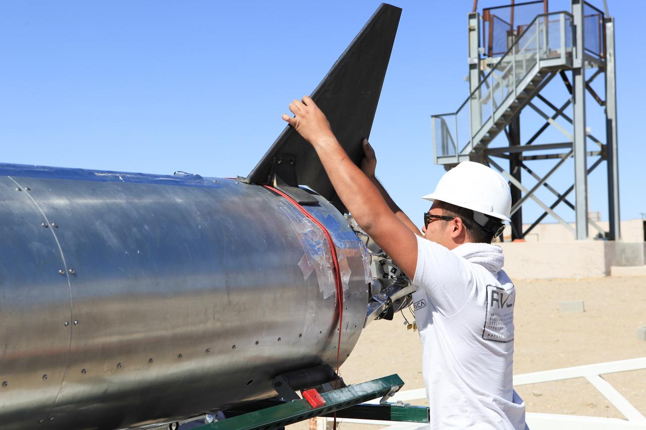 MOJAVE DESERT, Calif. – In the Mojave Desert in California, a student attaches a tail fin to the Garvey Spacecraft Corporation's Prospector P-18D rocket at the Friends of Amateur Rocketry launch site. The rocket is scheduled for flight June 15 with the RUBICS-1 payload on a high-altitude, suborbital flight. The rocket will carry four satellites made from four-inch cube sections. Collectively known as CubeSats, the satellites will record shock, vibrations and heat inside the rocket. They will not be released during the test flight, but the results will be used to prove or strengthen their designs before they are carried into orbit in 2014 on a much larger rocket. A new, lightweight carrier is also being tested for use on future missions to deploy the small spacecraft. The flight also is being watched closely as a model for trying out new or off-the-shelf technologies quickly before putting them in the pipeline for use on NASA's largest launchers. Built by several different organizations, including a university, a NASA field center and a high school, the spacecraft are four-inch cubes designed to fly on their own eventually, but will remain firmly attached to the rocket during the upcoming mission. For more information, visit http://www.nasa.gov/mission_pages/smallsats/elana/cubesatlaunchpreview.html Photo credit: NASA/Dimitri Gerondidakis