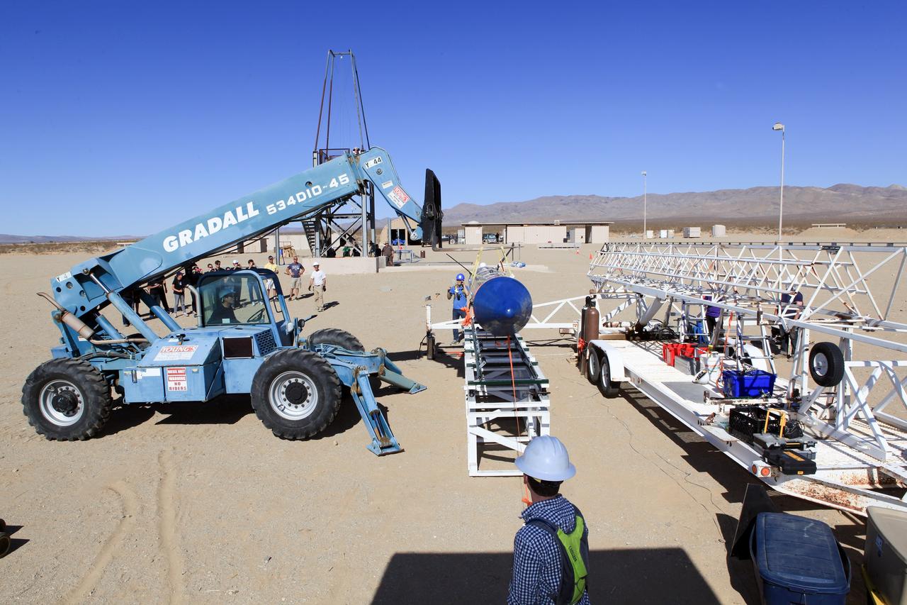 MOJAVE DESERT, Calif. – In the Mojave Desert in California, students and engineers assist as the Garvey Spacecraft Corporation's Prospector P-18D rocket is lifted into position for its scheduled launch on June 15 with the RUBICS-1 payload on a high-altitude, suborbital flight. The rocket will carry four satellites made from four-inch cube sections. Collectively known as CubeSats, the satellites will record shock, vibrations and heat inside the rocket. They will not be released during the test flight, but the results will be used to prove or strengthen their designs before they are carried into orbit in 2014 on a much larger rocket. A new, lightweight carrier is also being tested for use on future missions to deploy the small spacecraft. The flight also is being watched closely as a model for trying out new or off-the-shelf technologies quickly before putting them in the pipeline for use on NASA's largest launchers. Built by several different organizations, including a university, a NASA field center and a high school, the spacecraft are four-inch cubes designed to fly on their own eventually, but will remain firmly attached to the rocket during the upcoming mission. For more information, visit http://www.nasa.gov/mission_pages/smallsats/elana/cubesatlaunchpreview.html Photo credit: NASA/Dimitri Gerondidakis
