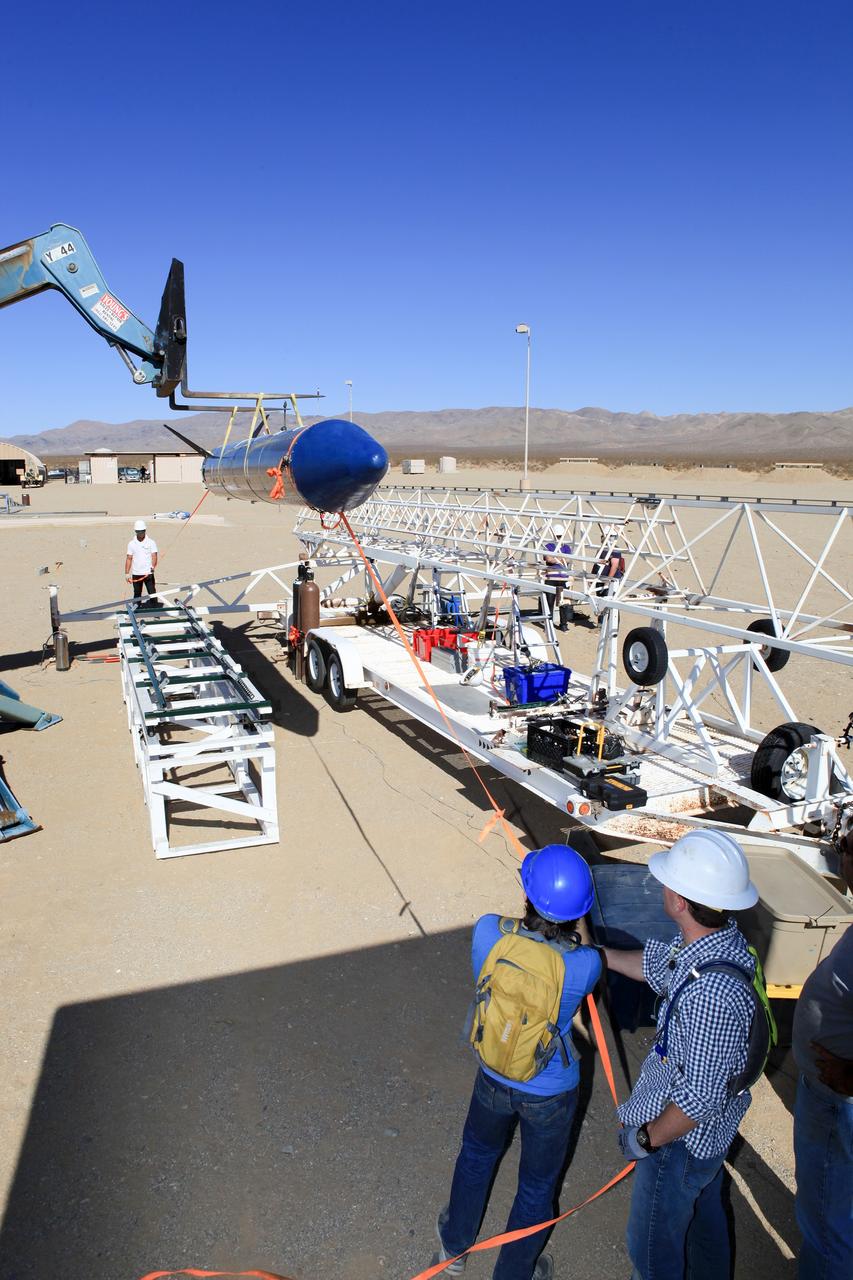 MOJAVE DESERT, Calif. – In the Mojave Desert in California, students and engineers assist as the Garvey Spacecraft Corporation's Prospector P-18D rocket is lifted into position for its scheduled launch on June 15 with the RUBICS-1 payload on a high-altitude, suborbital flight. The rocket will carry four satellites made from four-inch cube sections. Collectively known as CubeSats, the satellites will record shock, vibrations and heat inside the rocket. They will not be released during the test flight, but the results will be used to prove or strengthen their designs before they are carried into orbit in 2014 on a much larger rocket. A new, lightweight carrier is also being tested for use on future missions to deploy the small spacecraft. The flight also is being watched closely as a model for trying out new or off-the-shelf technologies quickly before putting them in the pipeline for use on NASA's largest launchers. Built by several different organizations, including a university, a NASA field center and a high school, the spacecraft are four-inch cubes designed to fly on their own eventually, but will remain firmly attached to the rocket during the upcoming mission. For more information, visit http://www.nasa.gov/mission_pages/smallsats/elana/cubesatlaunchpreview.html Photo credit: NASA/Dimitri Gerondidakis
