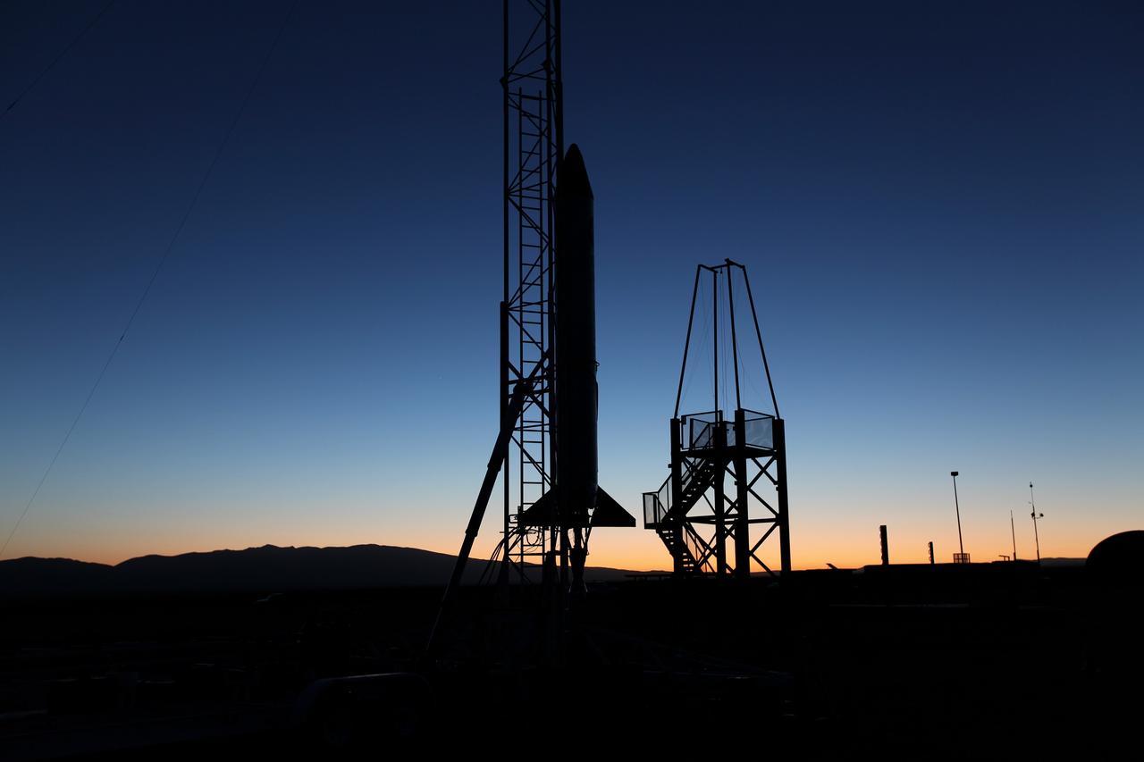 MOJAVE DESERT, Calif. – As the sun rises in the Mojave Desert in California, the Garvey Spacecraft Corporation's Prospector P-18D rocket is positioned for launch with the RUBICS-1 payload on a high-altitude, suborbital flight. The rocket will carry four satellites made from four-inch cube sections. Collectively known as CubeSats, the satellites will record shock, vibrations and heat inside the rocket. They will not be released during the test flight, but the results will be used to prove or strengthen their designs before they are carried into orbit in 2014 on a much larger rocket. A new, lightweight carrier is also being tested for use on future missions to deploy the small spacecraft. The flight also is being watched closely as a model for trying out new or off-the-shelf technologies quickly before putting them in the pipeline for use on NASA's largest launchers. Built by several different organizations, including a university, a NASA field center and a high school, the spacecraft are four-inch cubes designed to fly on their own eventually, but will remain firmly attached to the rocket during the upcoming mission. For more information, visit http://www.nasa.gov/mission_pages/smallsats/elana/cubesatlaunchpreview.html Photo credit: NASA/Dimitri Gerondidakis
