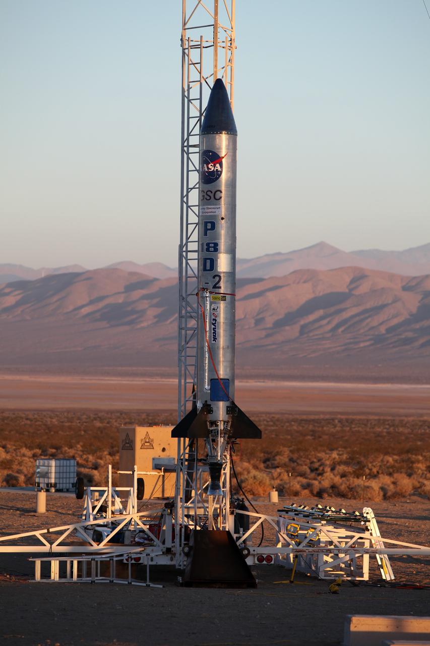 MOJAVE DESERT, Calif. – As the sun rises in the Mojave Desert in California, the Garvey Spacecraft Corporation's Prospector P-18D rocket is positioned for launch with the RUBICS-1 payload on a high-altitude, suborbital flight. The rocket will carry four satellites made from four-inch cube sections. Collectively known as CubeSats, the satellites will record shock, vibrations and heat inside the rocket. They will not be released during the test flight, but the results will be used to prove or strengthen their designs before they are carried into orbit in 2014 on a much larger rocket. A new, lightweight carrier is also being tested for use on future missions to deploy the small spacecraft. The flight also is being watched closely as a model for trying out new or off-the-shelf technologies quickly before putting them in the pipeline for use on NASA's largest launchers. Built by several different organizations, including a university, a NASA field center and a high school, the spacecraft are four-inch cubes designed to fly on their own eventually, but will remain firmly attached to the rocket during the upcoming mission. For more information, visit http://www.nasa.gov/mission_pages/smallsats/elana/cubesatlaunchpreview.html Photo credit: NASA/Dimitri Gerondidakis