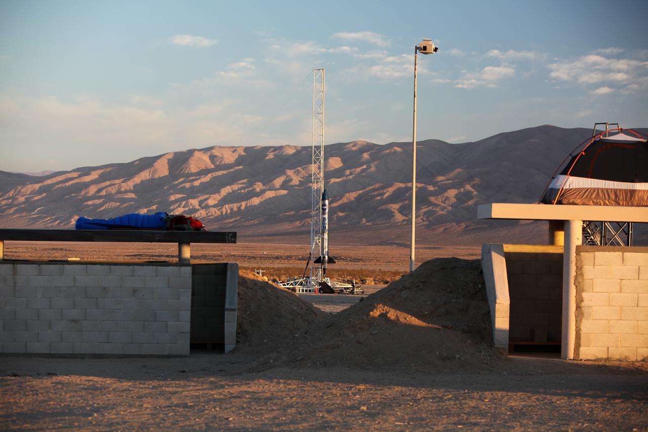 MOJAVE DESERT, Calif. – Viewed from a nearby bunker in the Mojave Desert in California, the Garvey Spacecraft Corporation's Prospector P-18D rocket is positioned for launch with the RUBICS-1 payload on a high-altitude, suborbital flight. The rocket will carry four satellites made from four-inch cube sections. Collectively known as CubeSats, the satellites will record shock, vibrations and heat inside the rocket. They will not be released during the test flight, but the results will be used to prove or strengthen their designs before they are carried into orbit in 2014 on a much larger rocket. A new, lightweight carrier is also being tested for use on future missions to deploy the small spacecraft. The flight also is being watched closely as a model for trying out new or off-the-shelf technologies quickly before putting them in the pipeline for use on NASA's largest launchers. Built by several different organizations, including a university, a NASA field center and a high school, the spacecraft are four-inch cubes designed to fly on their own eventually, but will remain firmly attached to the rocket during the upcoming mission. For more information, visit http://www.nasa.gov/mission_pages/smallsats/elana/cubesatlaunchpreview.html Photo credit: NASA/Dimitri Gerondidakis