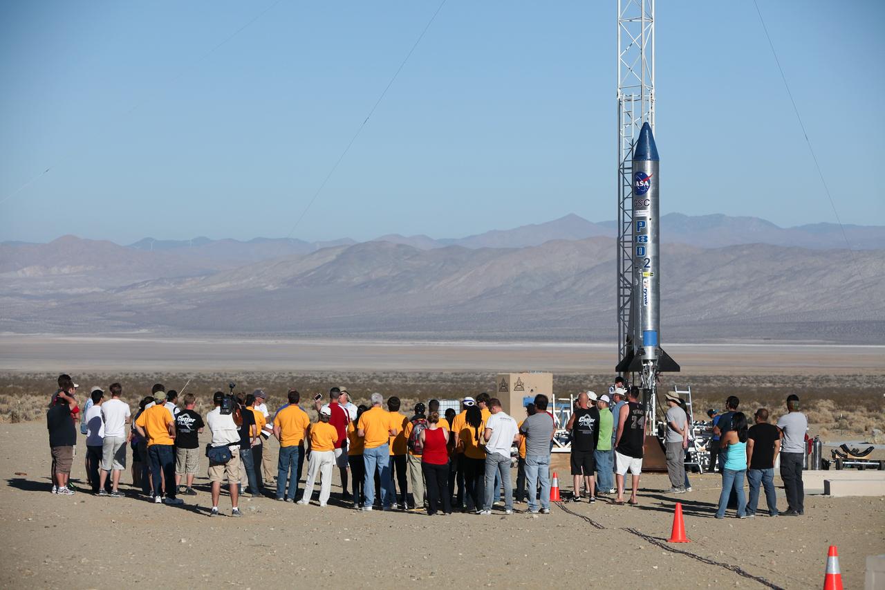 MOJAVE DESERT, Calif. – In the Mojave Desert in California, students and engineers participate in a pre-launch briefing before the lift off of the Garvey Spacecraft Corporation's Prospector P-18D rocket. The rocket is scheduled to launch the RUBICS-1 payload on a high-altitude, suborbital flight. The rocket will carry four satellites made from four-inch cube sections. The rocket reached a peak altitude of about 9,000 feet, however the parachute deployed prematurely and the vehicle continued on its trajectory, coasting and tumbling to a hard landing on its side. In spite of the rough ride, all four CubeSats were recovered. PhoneSat and RUBICS received data in flight, but sustained structural damage. CP-9 and StangSat fared better, and their teams are working to recover as much information as possible. Collectively known as CubeSats, the satellites were designed to record shock, vibrations and heat inside the rocket. The results will be used to prove or strengthen their designs before they are carried into orbit in 2014 on a much larger rocket. Built by several different organizations, including a university, a NASA field center and a high school, the spacecraft are four-inch cubes designed to fly on their own eventually, but will remain firmly attached to the rocket during the upcoming mission. For more information, visit http://www.nasa.gov/mission_pages/smallsats/elana/cubesatlaunchpreview.html Photo credit: NASA/Dimitri Gerondidakis