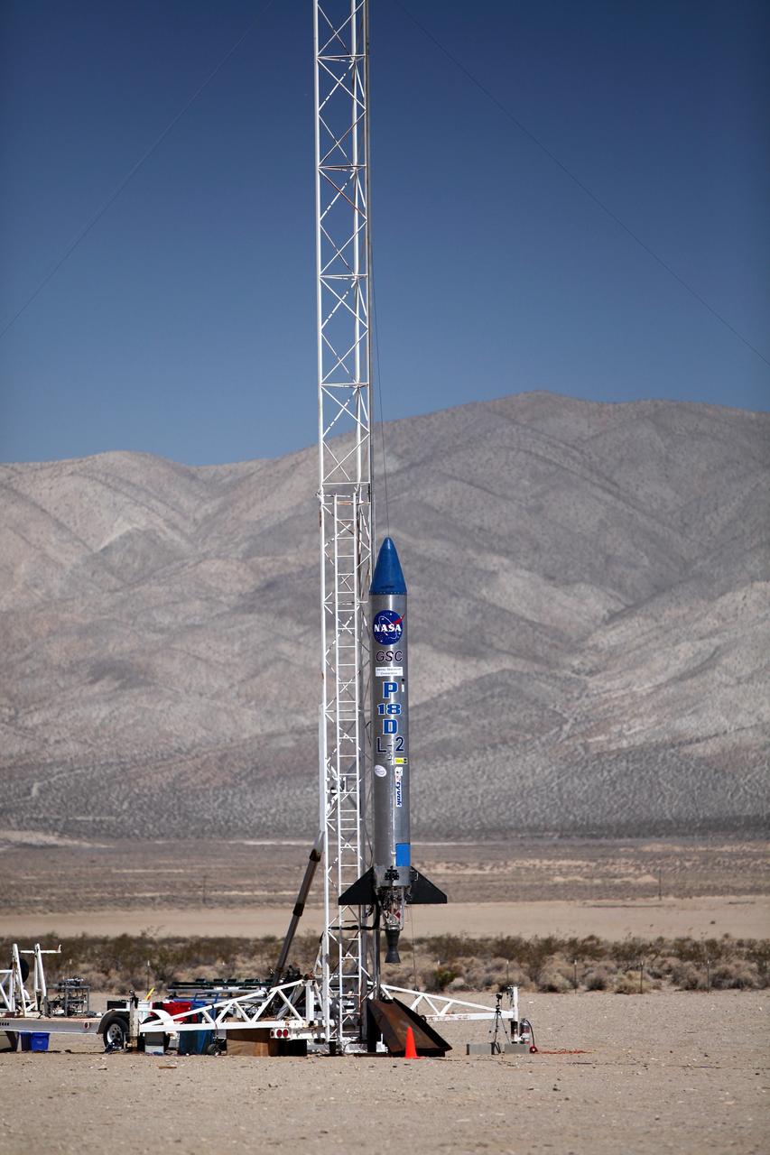 MOJAVE DESERT, Calif. – In the Mojave Desert in California, the Garvey Spacecraft Corporation's Prospector P-18D rocket is positioned for launch with the RUBICS-1 payload on a high-altitude, suborbital flight. The rocket will carry four satellites made from four-inch cube sections.      The rocket reached a peak altitude of about 9,000 feet, however the parachute deployed prematurely and the vehicle continued on its trajectory, coasting and tumbling to a hard landing on its side. In spite of the rough ride, all four CubeSats were recovered. PhoneSat and RUBICS received data in flight, but sustained structural damage. CP-9 and StangSat fared better, and their teams are working to recover as much information as possible. Collectively known as CubeSats, the satellites were designed to record shock, vibrations and heat inside the rocket. The results will be used to prove or strengthen their designs before they are carried into orbit in 2014 on a much larger rocket. Built by several different organizations, including a university, a NASA field center and a high school, the spacecraft are four-inch cubes designed to fly on their own eventually, but will remain firmly attached to the rocket during the upcoming mission. For more information, visit http://www.nasa.gov/mission_pages/smallsats/elana/cubesatlaunchpreview.html Photo credit: NASA/Dimitri Gerondidakis