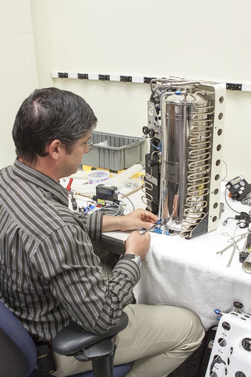 CAPE CANAVERAL, Fla. - NASA Kennedy Space Center Lead Engineer David Bush works on a prototype of a Cryogenic Refuge Alternative Supply System, or CryoRASS, in the Operations and Checkout Building. CryoRASS and a small liquid-air filled backpack called CryoBA, short for Cryogenic Breathing Apparatus, are being developed by a NASA Kennedy Space Center engineering team in collaboration with The National Institute for Occupational Safety and Health to provide miners with twice the amount of breathable and cooler air than traditional compressed systems. The technology also could be used for commercial applications, such as fire and military rescue operations, as well as NASA's future human spaceflight missions. Photo credit: NASA/Jim Gossmann
