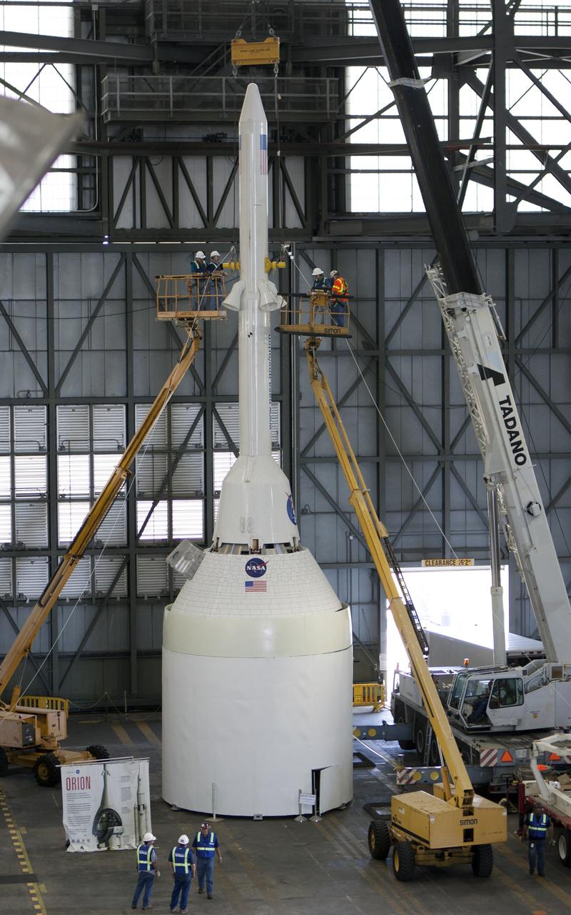CAPE CANAVERAL, Fla. -- In the transfer aisle of the Vehicle Assembly Building at NASA’s Kennedy Space Center in Florida, crane operators and technicians practice de-stacking operations on a full-size mock-up of the Orion spacecraft and launch abort system in order to keep processing procedures and skills current. Orion is the exploration spacecraft designed to carry crews to space beyond low Earth orbit. It will provide emergency abort capability, sustain the crew during the space travel and provide safe re-entry from deep space return velocities. Orion’s first unpiloted test flight is scheduled to launch in 2014 atop a Delta IV rocket. A second uncrewed flight test is scheduled for 2017 on NASA’s Space Launch System rocket. For more information, visit http://www.nasa.gov/orion. Photo credit: NASA/Jim Grossmann