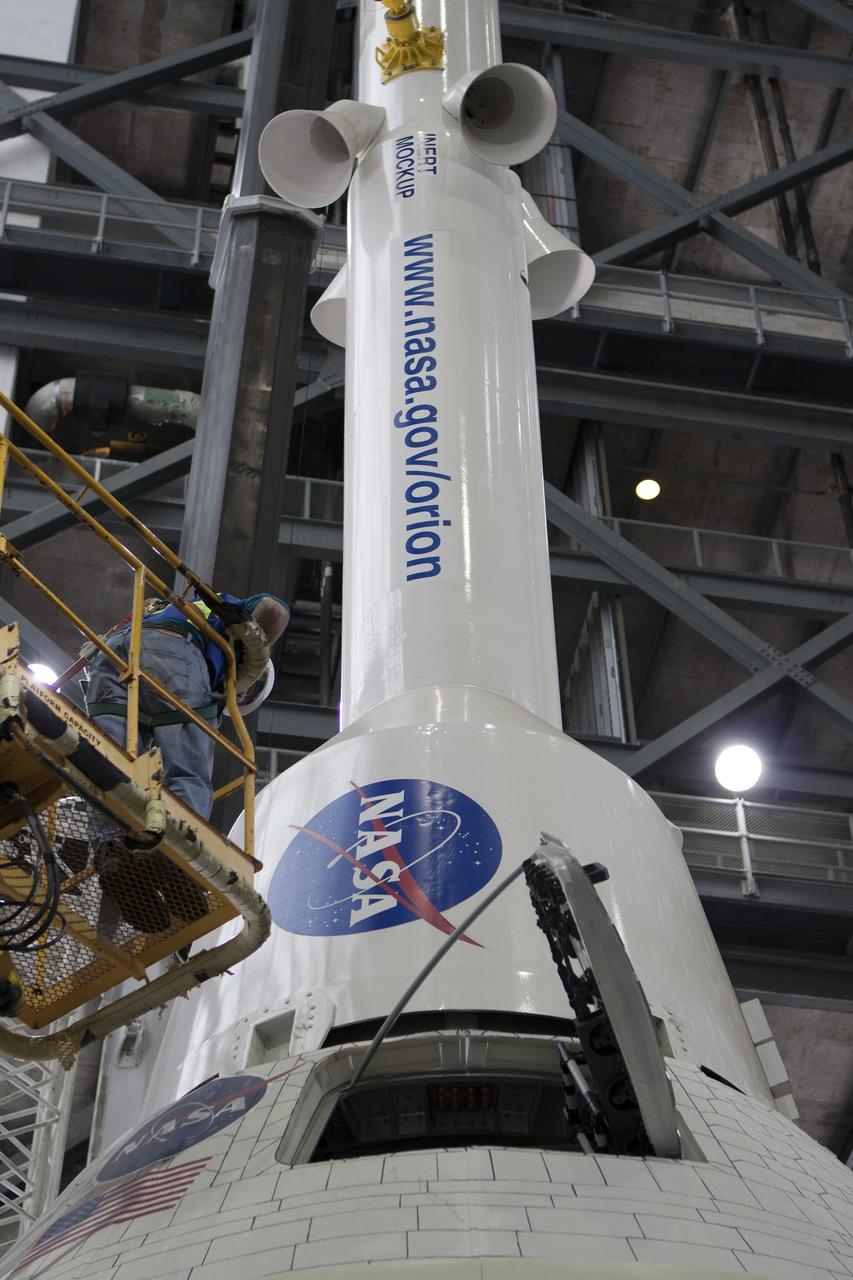CAPE CANAVERAL, Fla. -- In the transfer aisle of the Vehicle Assembly Building at NASA’s Kennedy Space Center in Florida, a technician monitors de-stacking operations on a full-size mock-up of the Orion spacecraft and launch abort system. Crane operators and technicians practice stacking and de-stacking operations in order to keep processing procedures and skills current. Orion is the exploration spacecraft designed to carry crews to space beyond low Earth orbit. It will provide emergency abort capability, sustain the crew during the space travel and provide safe re-entry from deep space return velocities. Orion’s first unpiloted test flight is scheduled to launch in 2014 atop a Delta IV rocket. A second uncrewed flight test is scheduled for 2017 on NASA’s Space Launch System rocket. For more information, visit http://www.nasa.gov/orion. Photo credit: NASA/Jim Grossmann