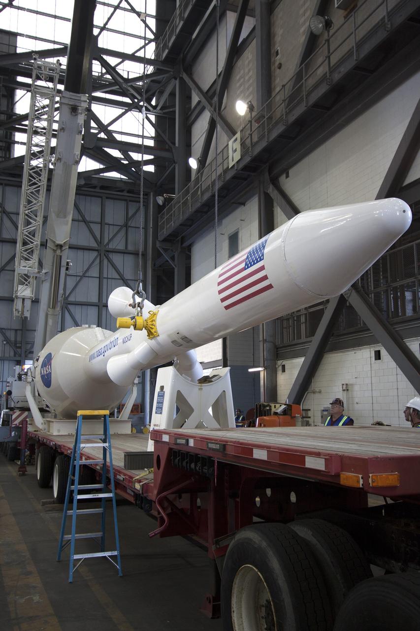CAPE CANAVERAL, Fla. -- In the transfer aisle of the Vehicle Assembly Building at NASA’s Kennedy Space Center in Florida, crane operators and technicians practice lowering a mock-up of the Orion launch abort system onto a transporter in order to keep processing procedures and skills current. Orion is the exploration spacecraft designed to carry crews to space beyond low Earth orbit. It will provide emergency abort capability, sustain the crew during the space travel and provide safe re-entry from deep space return velocities. Orion’s first unpiloted test flight is scheduled to launch in 2014 atop a Delta IV rocket. A second uncrewed flight test is scheduled for 2017 on NASA’s Space Launch System rocket. For more information, visit http://www.nasa.gov/orion. Photo credit: NASA/Jim Grossmann