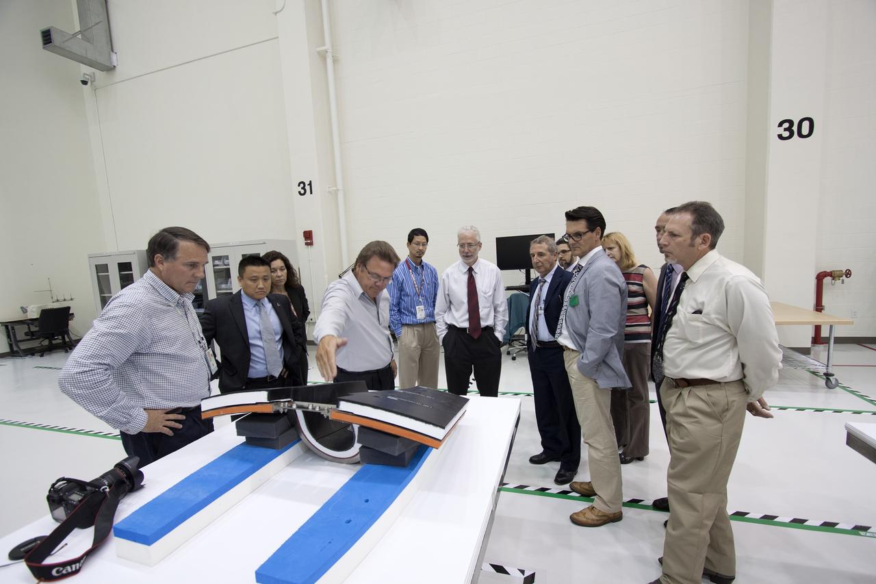 CAPE CANAVERAL, Fla. – Representatives from the European Space Agency, or ESA, toured the Operations and Checkout Building high bay at NASA’s Kennedy Space Center in Florida. Pointing at thermal protection system tiles is Jules Schneider, Lockheed Martin senior manager. At right, in the blue suit, is Bernardo Patti, ESA manager of International Space Station Operations. Standing next to Patti is Nico Dettman, ESA Space Transportation Department director.    Orion is the exploration spacecraft designed to carry crews to space beyond low Earth orbit. It will provide emergency abort capability, sustain the crew during the space travel and provide safe re-entry from deep space return velocities. Orion’s first unpiloted test flight is scheduled to launch in 2014 atop a Delta IV rocket. A second uncrewed flight test is scheduled for 2017 on NASA’s Space Launch System rocket. For more information, visit http://www.nasa.gov/orion. Photo credit: NASA/Jim Grossmann