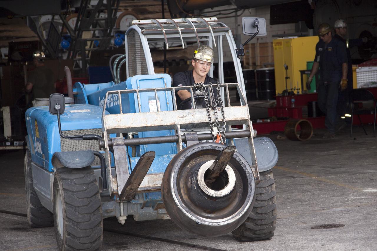 CAPE CANAVERAL, Fla. – Inside the Vehicle Assembly Building at NASA’s Kennedy Space Center in Florida, a technician uses a forklift to carry an old roller shaft bearing that was removed from crawler-transporter 2, or CT-2. New roller shaft bearings will be installed on CT-2.      Work continues in high bay 2 to upgrade CT-2. The modifications are designed to ensure CT-2’s ability to transport launch vehicles currently in development, such as the agency’s Space Launch System, to the launch pad. The Ground Systems Development and Operations Program office at Kennedy is overseeing the upgrades. For more than 45 years the crawler-transporters were used to transport the mobile launcher platform and the Apollo-Saturn V rockets and, later, space shuttles to Launch Pads 39A and B. For more information, visit: http://www.nasa.gov/exploration/systems/ground/crawler-transporter_bearings.html. Photo credit: NASA/Jim Grossmann
