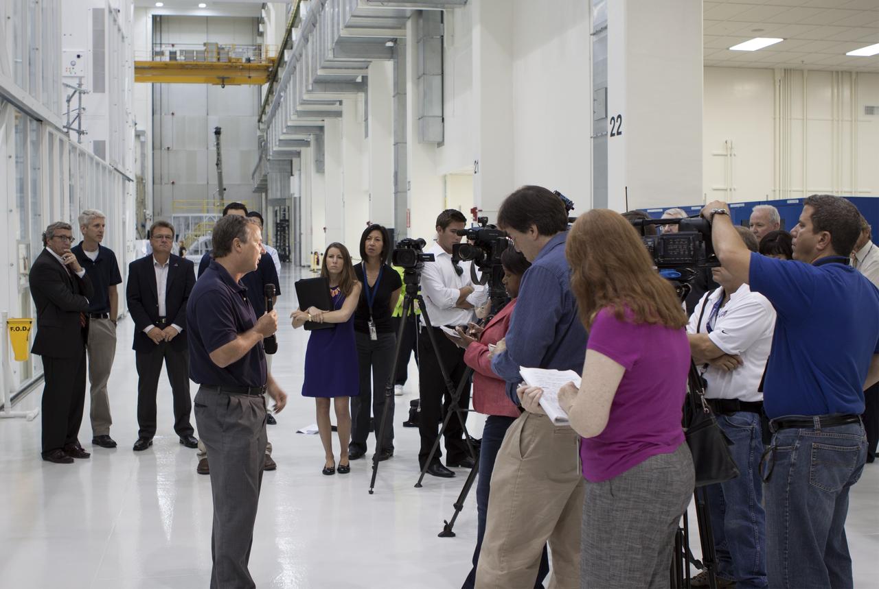 CAPE CANAVERAL, Fla. – Inside the Operations and Checkout Building high bay at NASA’s Kennedy Space Center in Florida, members of the media receive an on activities in NASA’s Ground Systems Development and Operations, or GSDO, Program, Space Launch System and Orion crew module for Exploration Test Flight 1.  Speaking to the media about the Space Launch System is Tom Erdman, from Marshall Space Flight Center’s Kennedy resident office.    Orion is the exploration spacecraft designed to carry crews to space beyond low Earth orbit. It will provide emergency abort capability, sustain the crew during the space travel and provide safe re-entry from deep space return velocities. Orion’s first unpiloted test flight is scheduled to launch in 2014 atop a Delta IV rocket. A second uncrewed flight test is scheduled for 2017 on NASA’s Space Launch System rocket. For more information, visit http://www.nasa.gov/orion. Photo credit: NASA/Jim Grossmann