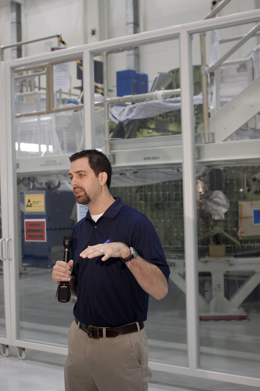 CAPE CANAVERAL, Fla. – Inside the Operations and Checkout Building high bay at NASA’s Kennedy Space Center in Florida, members of the media receive an on activities in NASA’s Ground Systems Development and Operations, or GSDO, Program, Space Launch System and Orion crew module for Exploration Test Flight 1. Speaking to the media is Jeremy Parsons, chief of the GSDO Operations Integration Office at Kennedy.    Orion is the exploration spacecraft designed to carry crews to space beyond low Earth orbit. It will provide emergency abort capability, sustain the crew during the space travel and provide safe re-entry from deep space return velocities. Orion’s first unpiloted test flight is scheduled to launch in 2014 atop a Delta IV rocket. A second uncrewed flight test is scheduled for 2017 on NASA’s Space Launch System rocket. For more information, visit http://www.nasa.gov/orion. Photo credit: NASA/Jim Grossmann