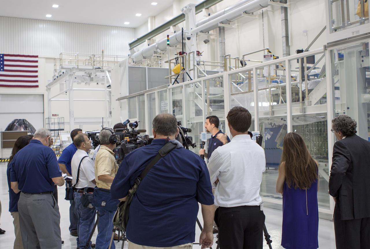 CAPE CANAVERAL, Fla. – Inside the Operations and Checkout Building high bay at NASA’s Kennedy Space Center in Florida, members of the media receive an on activities in NASA’s Ground Systems Development and Operations, or GSDO, Program, Space Launch System and Orion crew module for Exploration Test Flight 1. Speaking to the media is Jeremy Parsons, chief of the GSDO Operations Integration Office at Kennedy.    Orion is the exploration spacecraft designed to carry crews to space beyond low Earth orbit. It will provide emergency abort capability, sustain the crew during the space travel and provide safe re-entry from deep space return velocities. Orion’s first unpiloted test flight is scheduled to launch in 2014 atop a Delta IV rocket. A second uncrewed flight test is scheduled for 2017 on NASA’s Space Launch System rocket. For more information, visit http://www.nasa.gov/orion. Photo credit: NASA/Jim Grossmann