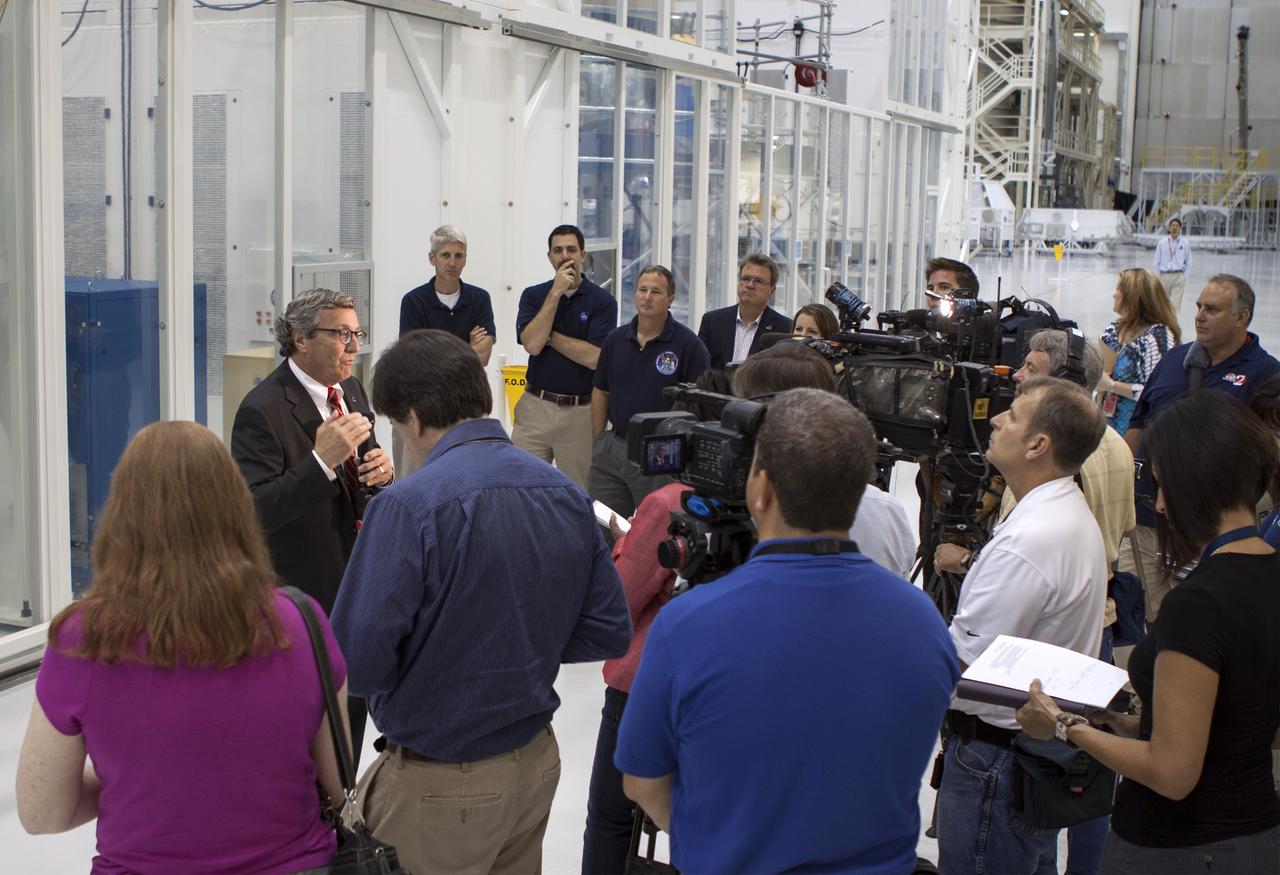 CAPE CANAVERAL, Fla. – Inside the Operations and Checkout Building high bay at NASA’s Kennedy Space Center in Florida, members of the media receive an on activities in NASA’s Ground Systems Development and Operations, or GSDO, Program, Space Launch System and Orion crew module for Exploration Test Flight 1. Speaking to the media is Larry Price, Lockheed Martin deputy program manager for Orion. In the background, from left are Scott Wilson, manager of Orion Production Operations at Kennedy Jeremy Parsons, chief of the GSDO Operations Integration Office at Kennedy Tom Erdman, from Marshall Space Flight Center’s Kennedy resident office and Jules Schneider, Lockheed Martin manager of Orion Production Operations.    Orion is the exploration spacecraft designed to carry crews to space beyond low Earth orbit. It will provide emergency abort capability, sustain the crew during the space travel and provide safe re-entry from deep space return velocities. Orion’s first unpiloted test flight is scheduled to launch in 2014 atop a Delta IV rocket. A second uncrewed flight test is scheduled for 2017 on NASA’s Space Launch System rocket. For more information, visit http://www.nasa.gov/orion. Photo credit: NASA/Jim Grossmann
